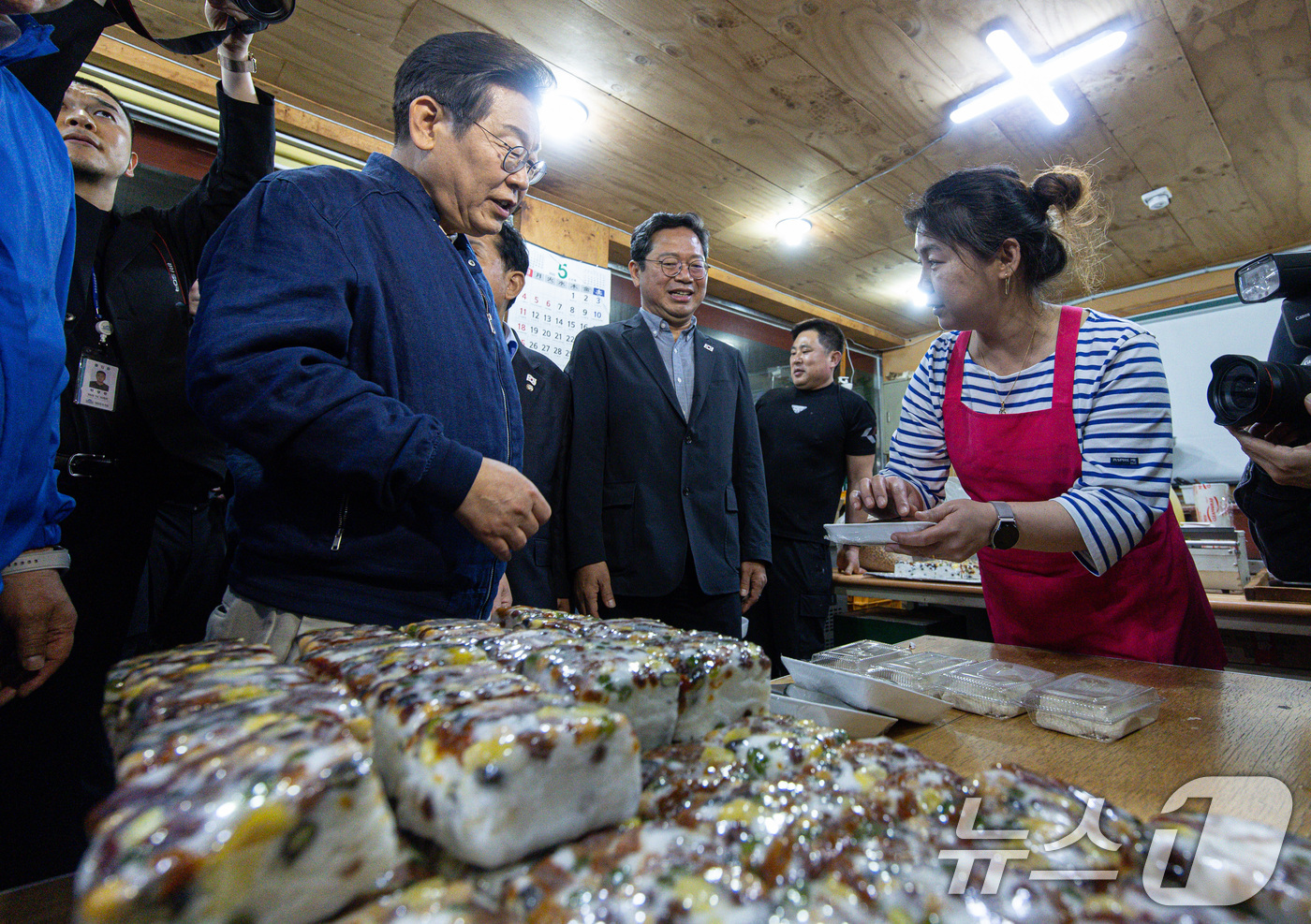 (연천=뉴스1) 이재명 기자 = 이재명 더불어민주당 대통령 후보가 1일 오후 경기도 연천군 전곡시외터미널 인근에 위치한 떡집을 찾아 떡을 구매하고 있다. 2025.5.1/뉴스1
