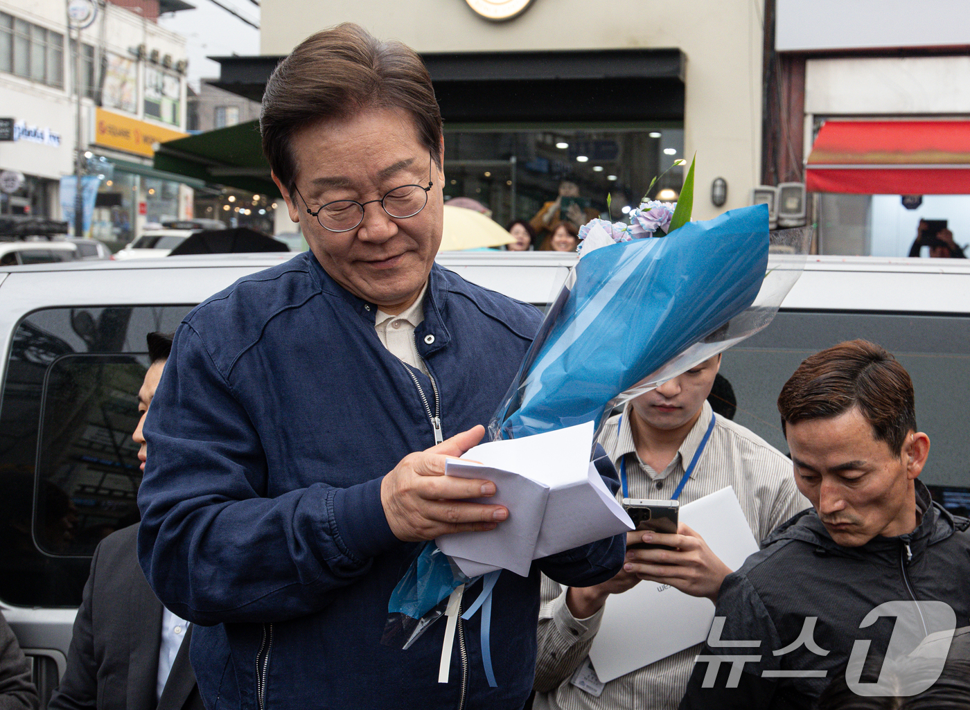 (연천=뉴스1) 이재명 기자 = 이재명 더불어민주당 대통령 후보가 1일 오후 경기도 연천군 전곡시외터미널 인근에서 선물받은 꽃다발과 편지를 살펴보고 있다. 2025.5.1/뉴스1