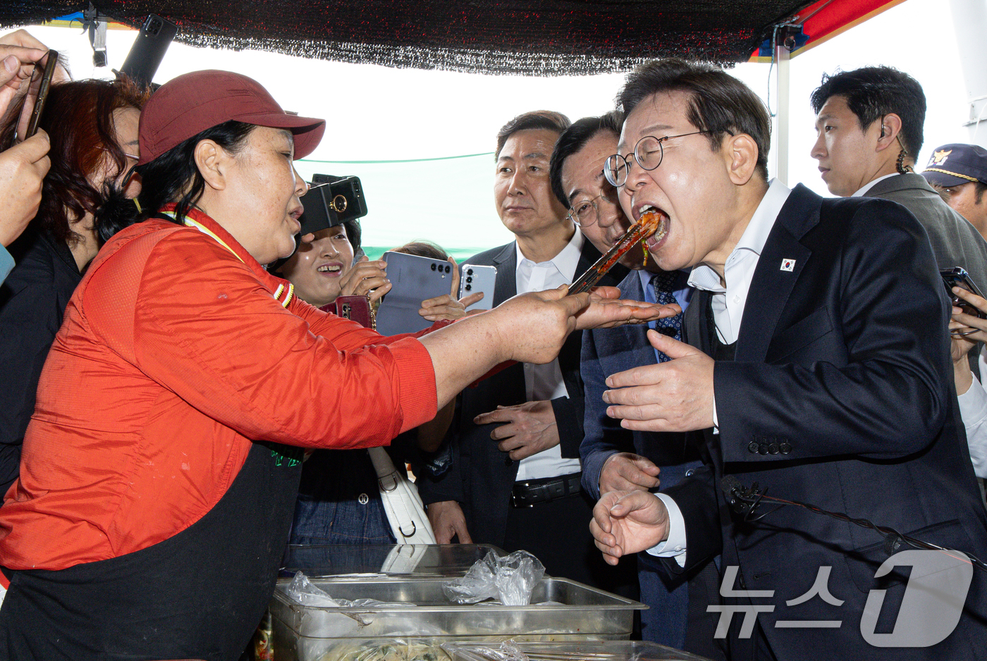 (함안=뉴스1) 이재명 기자 = 경청투어에 나선 이재명 더불어민주당 대통령 후보가 10일 오전 경남 함양군 가야읍 가야시장에서 김치를 맛보고 있다. 2025.5.10/뉴스1