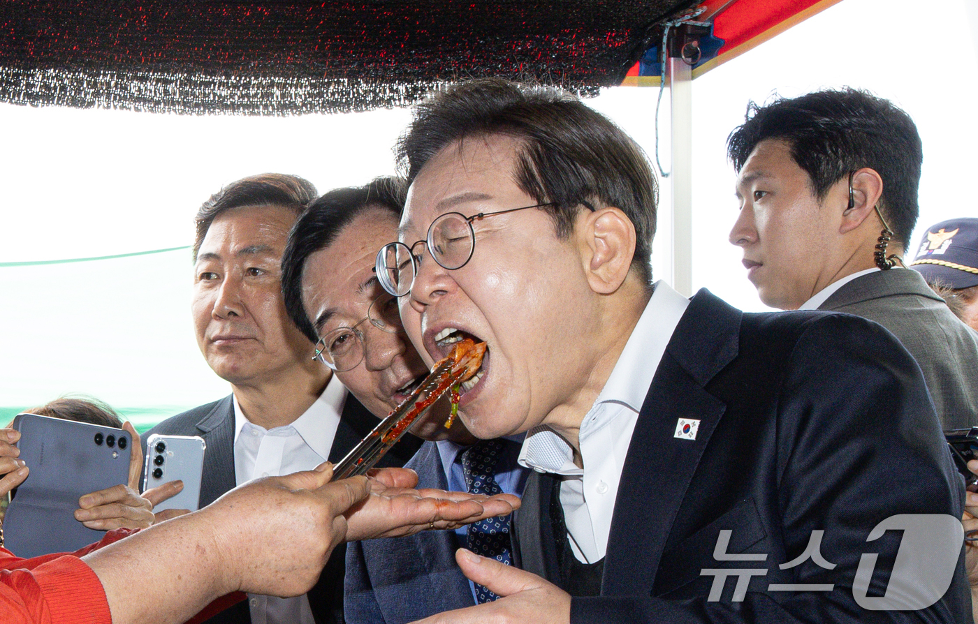 (함안=뉴스1) 이재명 기자 = 경청투어에 나선 이재명 더불어민주당 대통령 후보가 10일 오전 경남 함양군 가야읍 가야시장에서 김치를 맛보고 있다. 2025.5.10/뉴스1