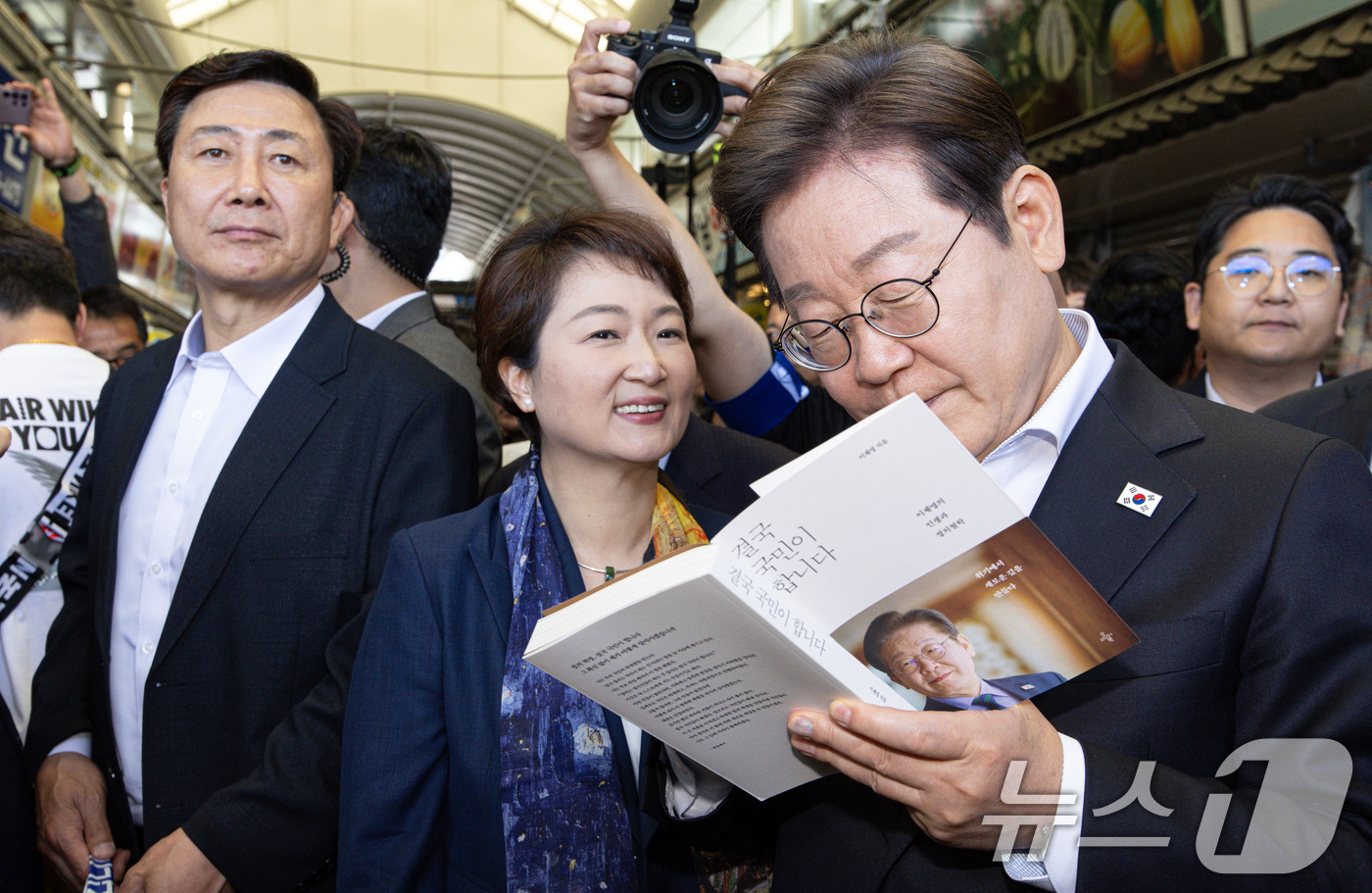 (함안=뉴스1) 이재명 기자 = 경청투어에 나선 이재명 더불어민주당 대통령 후보가 10일 오전 경남 함안군 가야읍 가야시장에서 한 시민 요청으로 책에 사인하고 있다. 2025.5. …