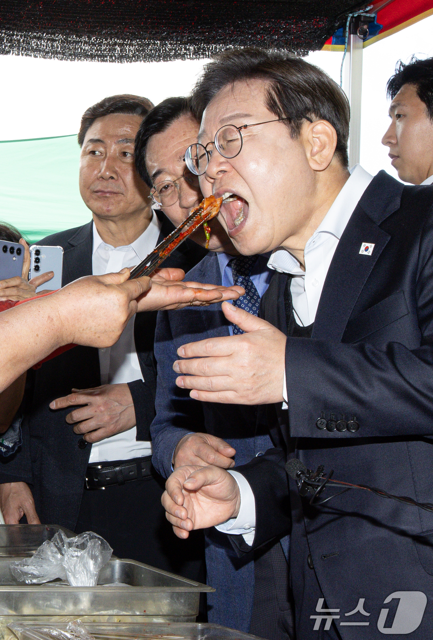 (함안=뉴스1) 이재명 기자 = 경청투어에 나선 이재명 더불어민주당 대통령 후보가 10일 오전 경남 함안군 가야읍 가야시장에서 김치를 맛보고 있다. 2025.5.10/뉴스1