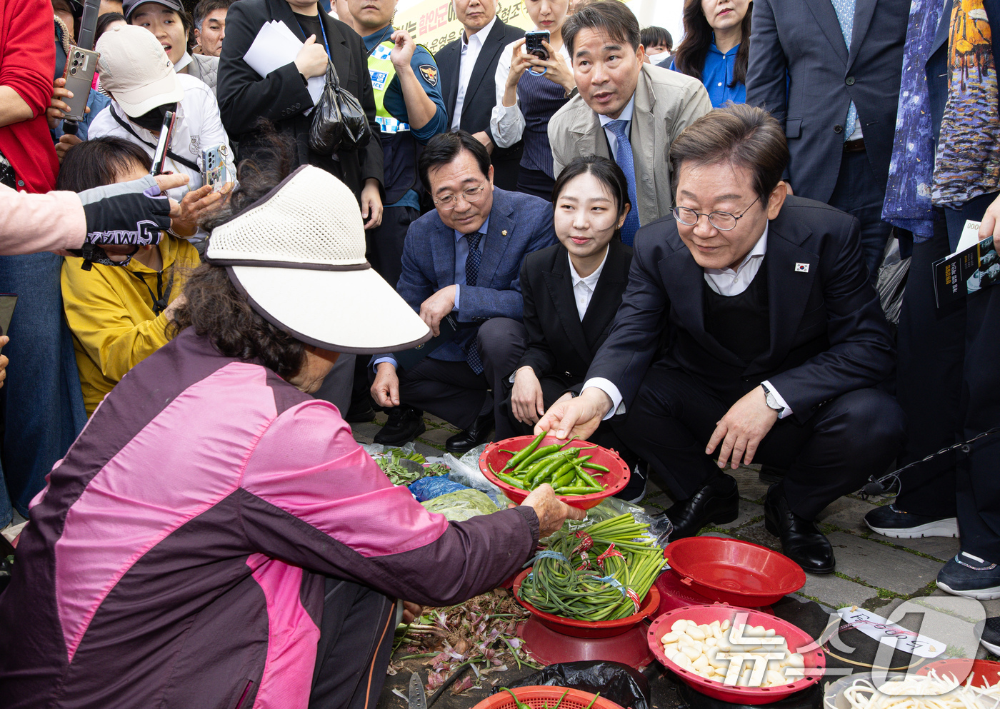 (함안=뉴스1) 이재명 기자 = 경청투어에 나선 이재명 더불어민주당 대통령 후보가 10일 오전 경남 함안군 가야읍 가야시장에서 고추를 구입하고 있다. 2025.5.10/뉴스1