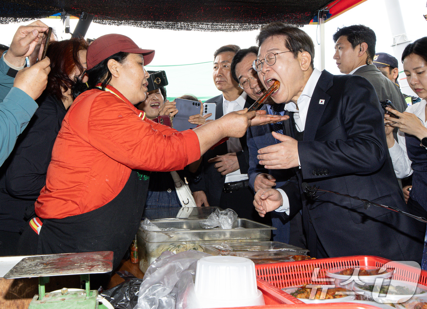 (함안=뉴스1) 이재명 기자 = 경청투어에 나선 이재명 더불어민주당 대통령 후보가 10일 오전 경남 함안군 가야읍 가야시장에서 김치를 맛보고 있다. 2025.5.10/뉴스1