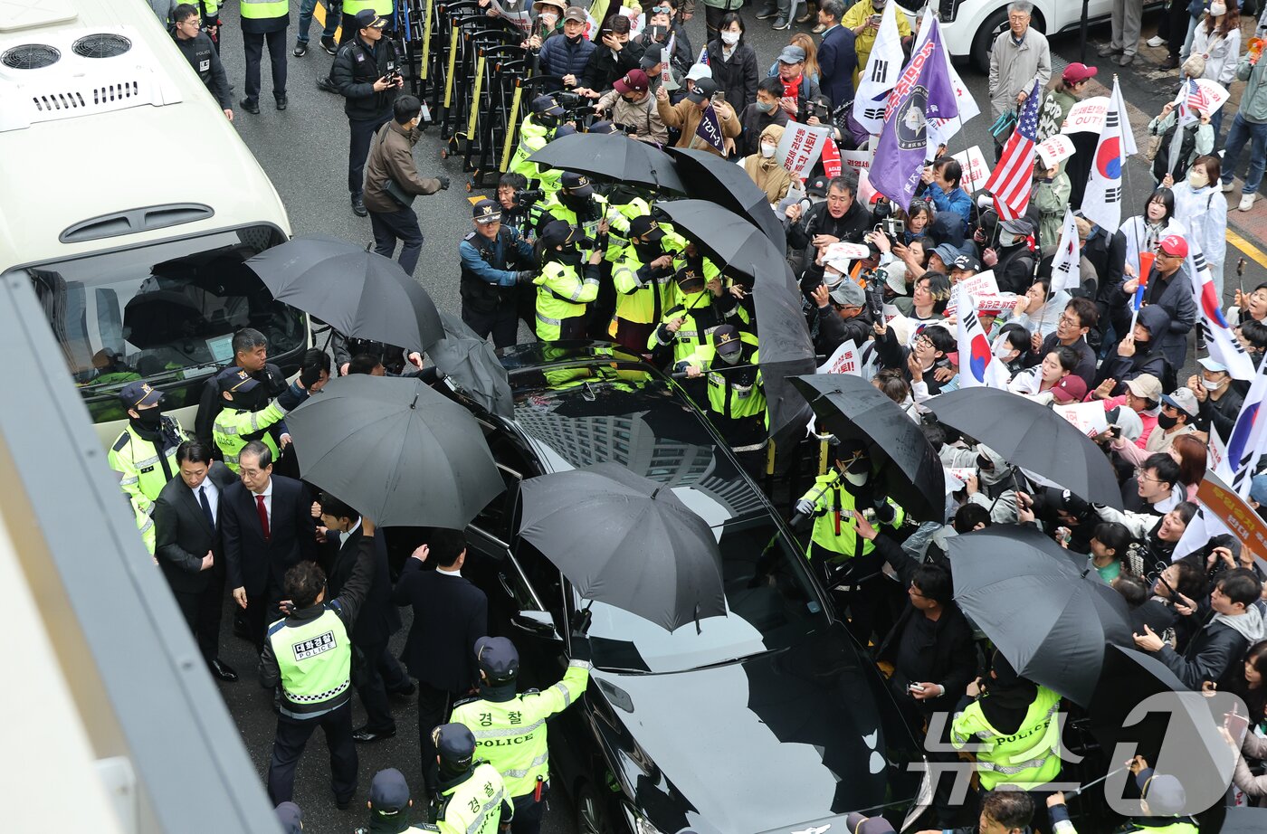 본문 이미지 - 국민의힘에 입당한 한덕수 대선 예비후보가 10일 서울 여의도 중앙당사에서 긴급 기자회견을 하기 위해 당사로 들어서고 있다. 오른쪽은 김문수 후보 지지자들. 2025.5.10/뉴스1 ⓒ News1 안은나 기자