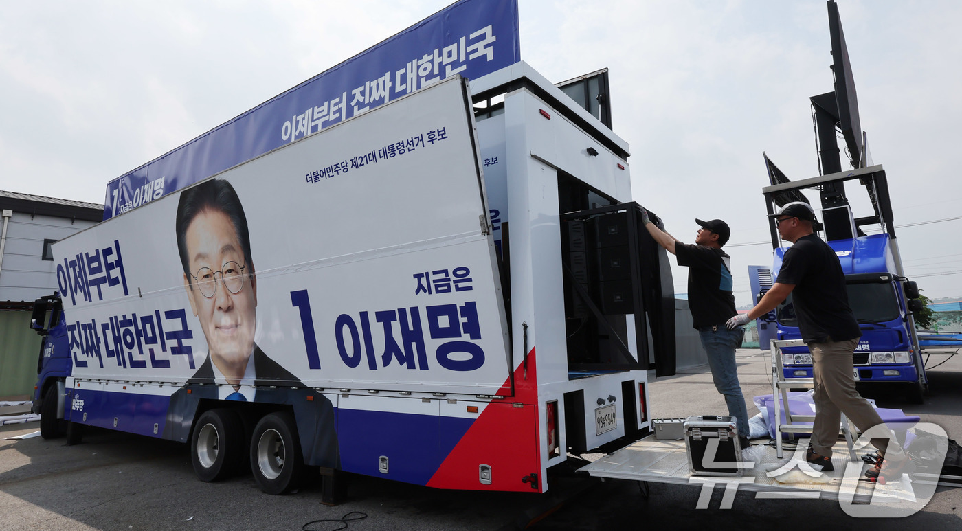 (양주=뉴스1) 박지혜 기자 = 제21대 대통령 선거 후보 등록 마감일인 11일 경기도 양주시 한 차량광고업체에 관계자들이 이재명 더불어민주당 대통령 후보 선거운동 유세차량을 제작 …