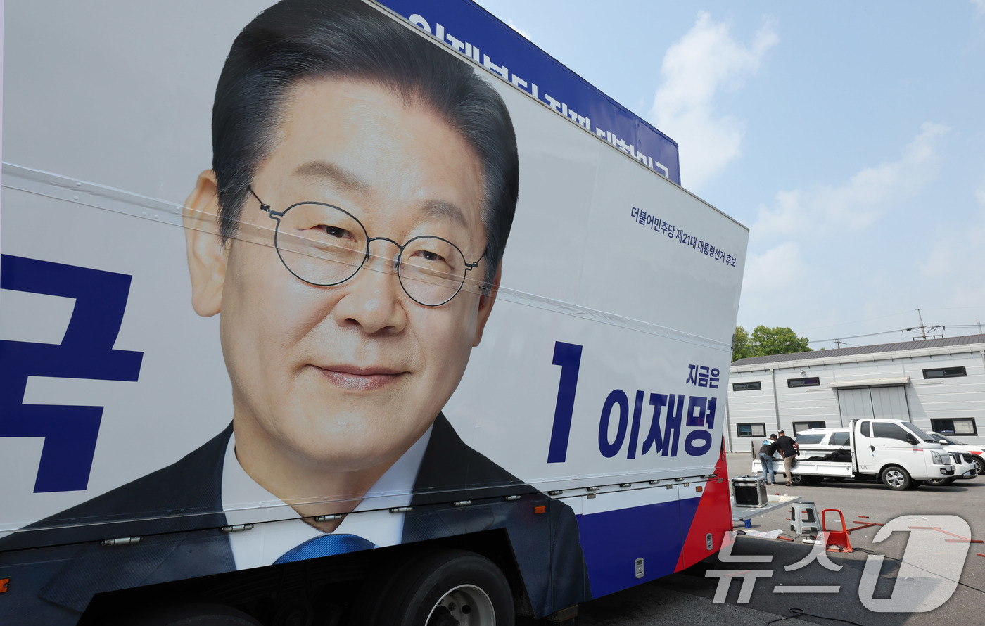 (양주=뉴스1) 박지혜 기자 = 제21대 대통령 선거 후보 등록 마감일인 11일 경기도 양주시 한 차량광고업체에 관계자들이 이재명 더불어민주당 대통령 후보 선거운동 유세차량을 제작 …