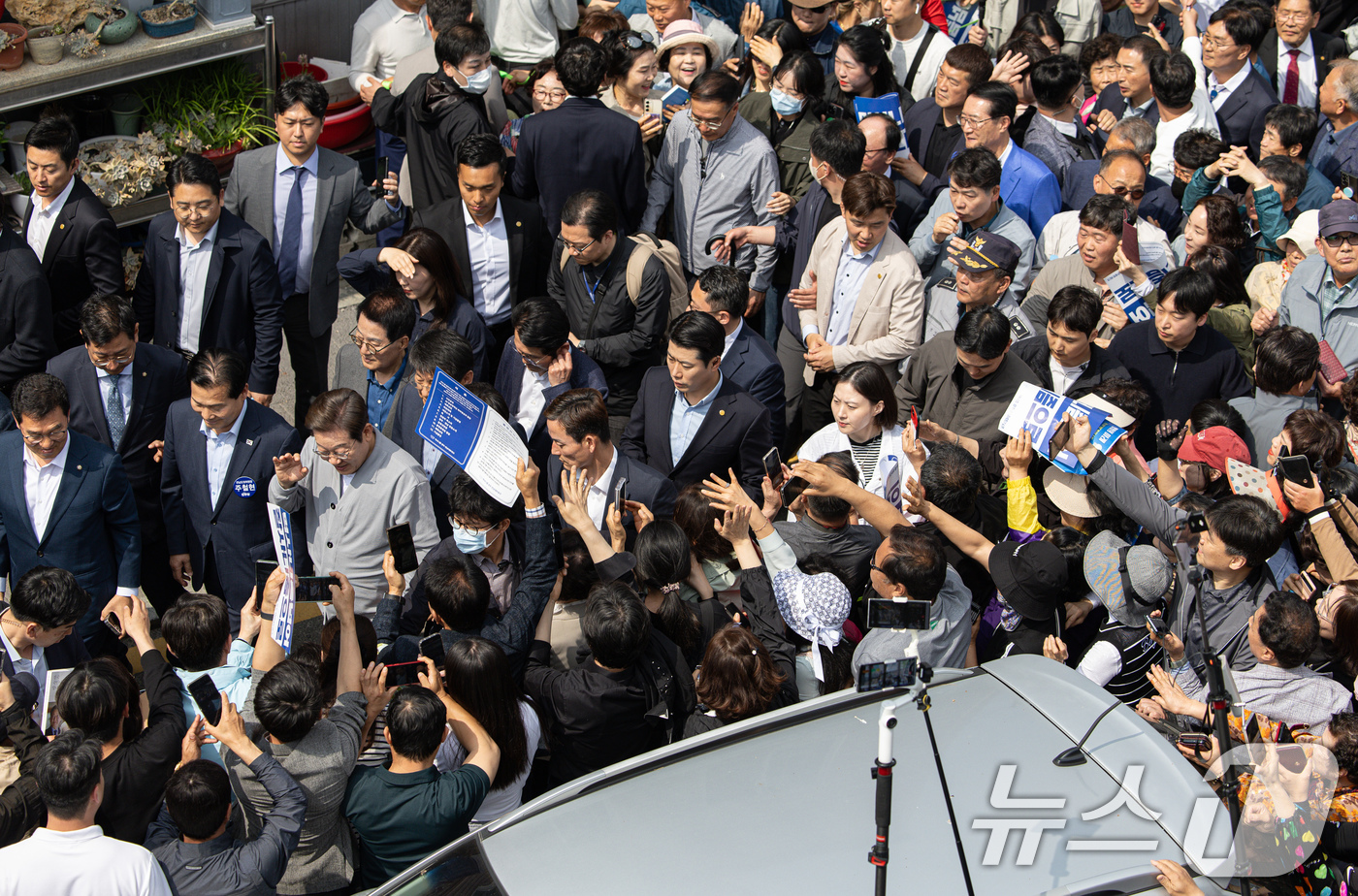 (영암=뉴스1) 이재명 기자 = 경청투어에 나선 이재명 더불어민주당 대통령 후보가 11일 오후 전남 영암군 독천낙지거리에서 시민들과 인사를 나누고 있다. 2025.5.11/뉴스1