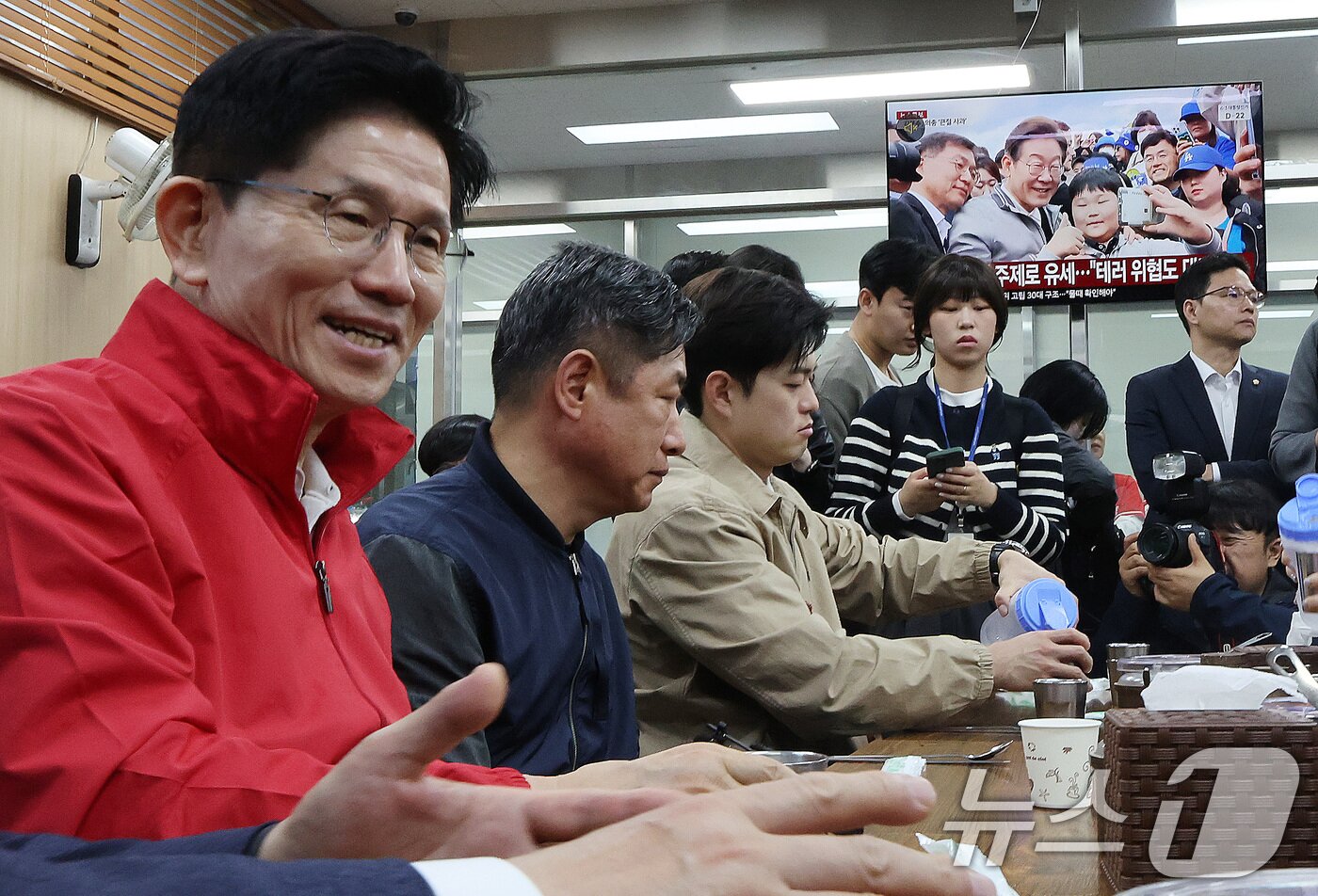 본문 이미지 - 제21대 대통령 선거 공식 선거운동이 시작된 12일 새벽 서울 송파구 양재대로 가락시장에서 김문수 국민의힘 대선 후보가 상인들과 아침식사를 준비하는 가운데 식당에 진열된 텔레비전으로 이재명 더불어민주당 대선 후보 뉴스가 송출되고 있다. 2025.5.12/뉴스1 ⓒ News1 이동해 기자