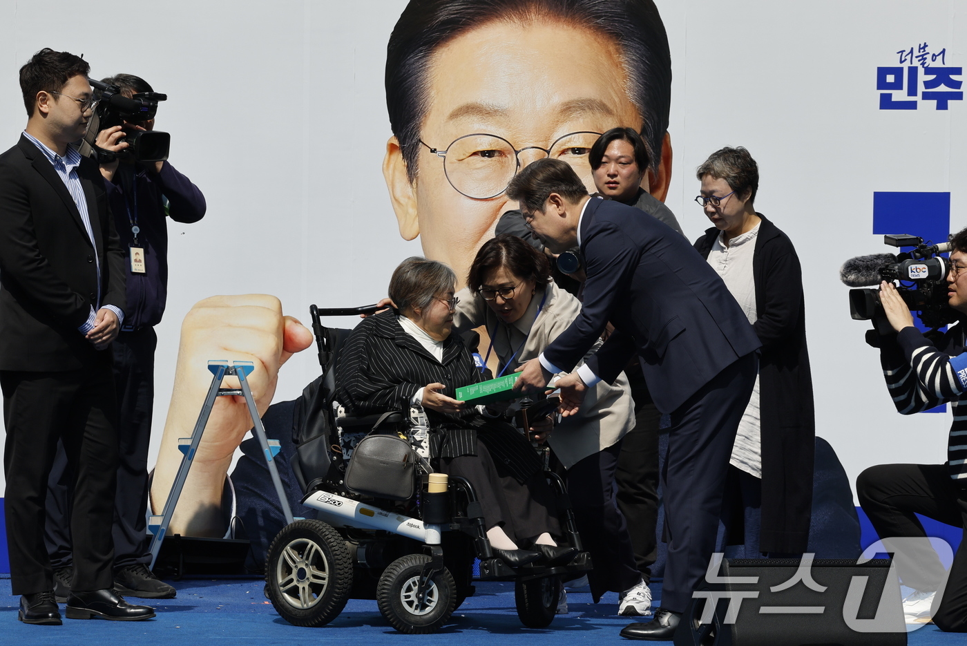 (서울=뉴스1) 안은나 기자 = 이재명 더불어민주당 대통령 후보가 12일 오전 서울 중구 청계광장에서 '빛의 혁명' 광화문 유세 시작을 알리며 박김영희 씨에게 녹서를 전달 받고 있 …