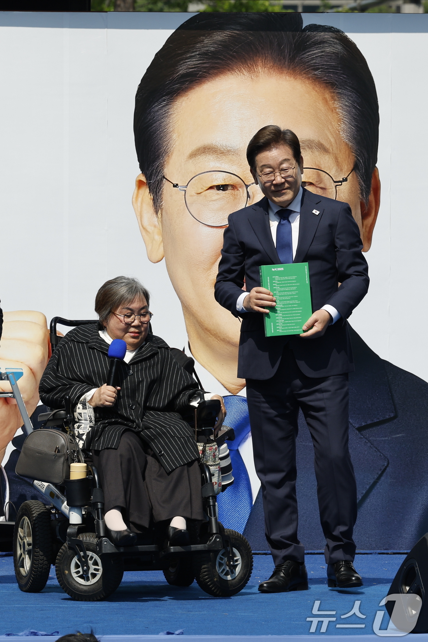 (서울=뉴스1) 안은나 기자 = 이재명 더불어민주당 대통령 후보가 12일 오전 서울 중구 청계광장에서 '빛의 혁명' 광화문 유세 시작을 알리며 박김영희 씨에게 녹서를 전달 받고 있 …