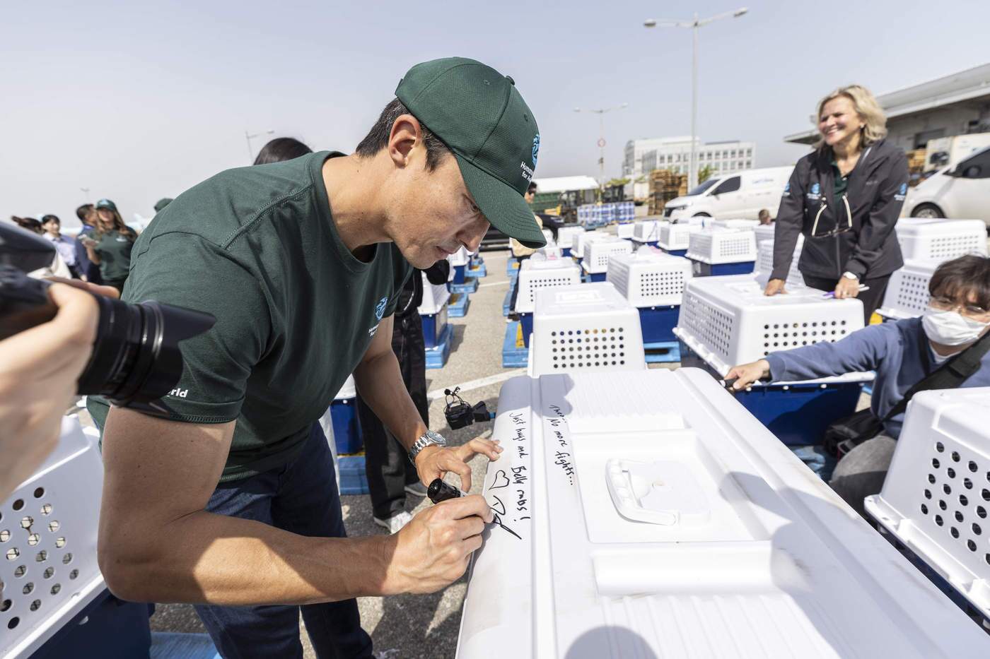 본문 이미지 - 다니엘 헤니가 미국으로 이송되는 구조견들의 케이지에 메시지를 적고 있다&#40;휴메인 월드 포 애니멀즈 제공&#41;. ⓒ 뉴스1