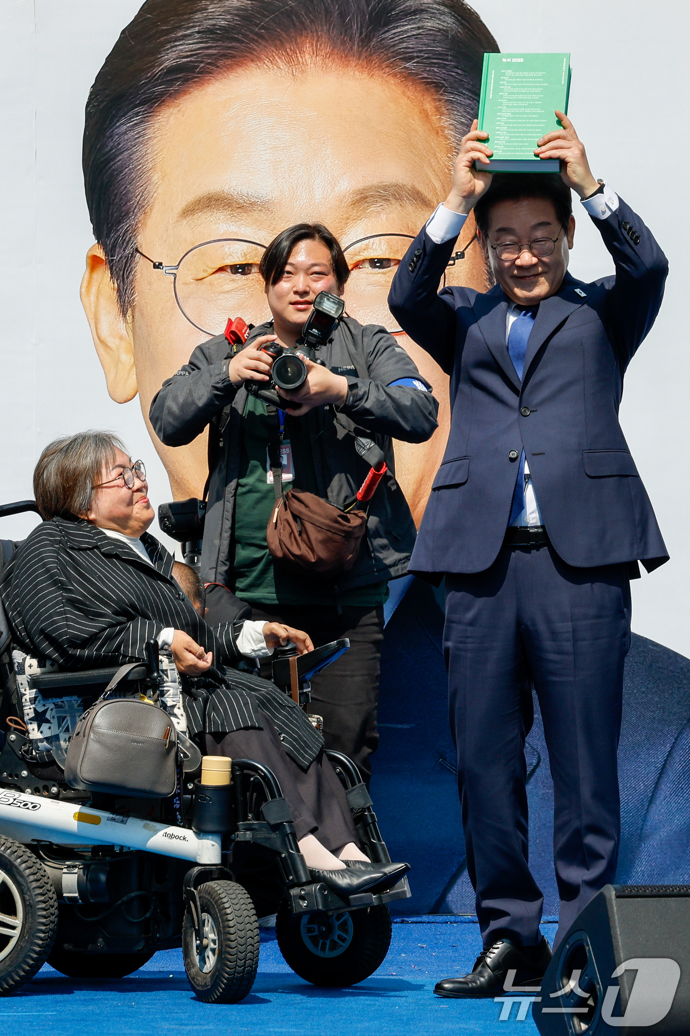 (서울=뉴스1) 안은나 기자 = 이재명 더불어민주당 대통령 후보가 공식 선거운동 첫날인 12일 오전 서울 중구 청계광장에서 열린 출정식에서 박김영희 씨에게 녹서를 전달 받고 있다. …