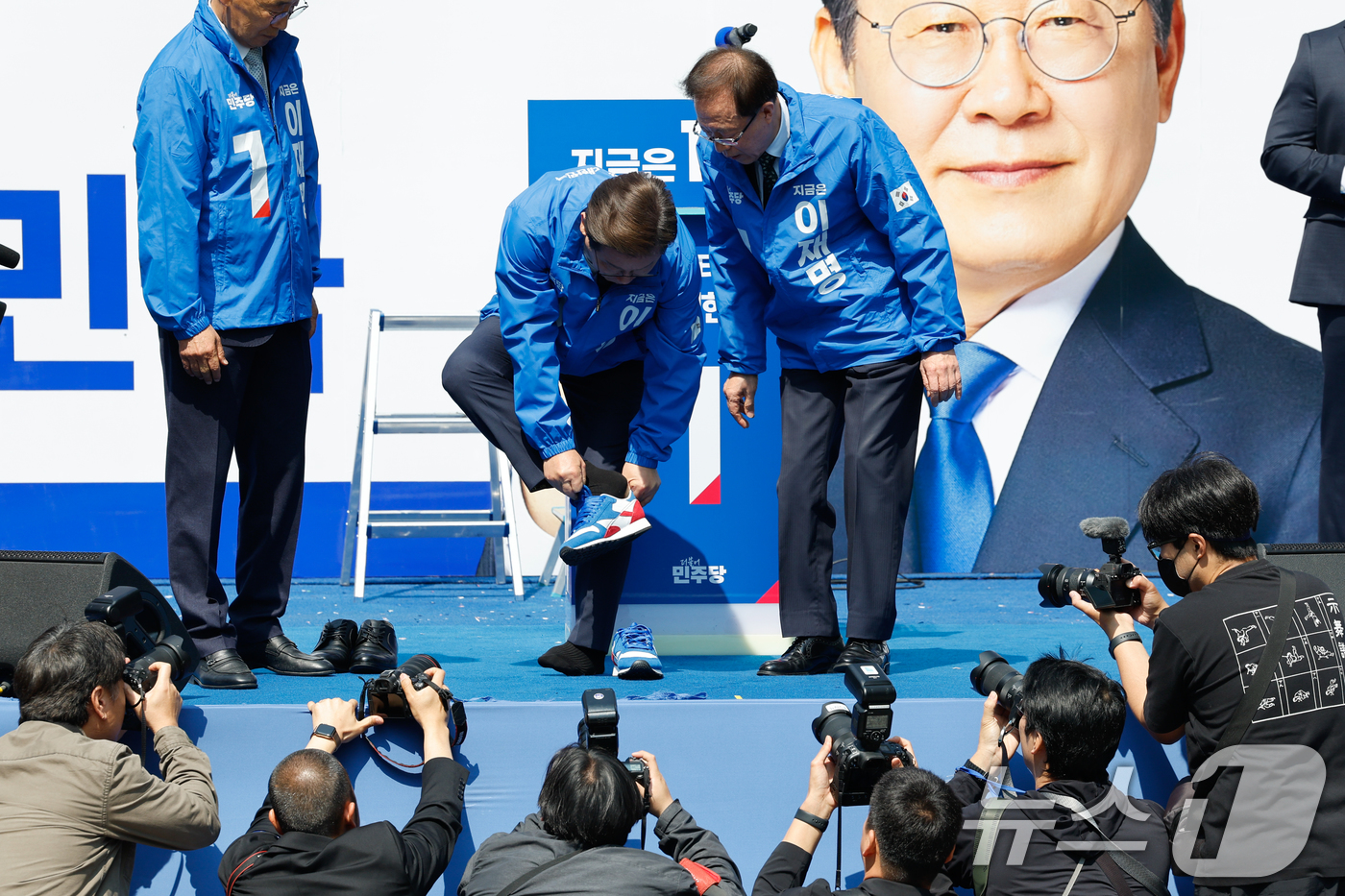 (서울=뉴스1) 안은나 기자 = 이재명 더불어민주당 대통령 후보가 공식 선거운동 첫날인 12일 오전 서울 중구 청계광장에서 열린 출정식에서 선거운동복을 입은 뒤 운동화를 신고 있다 …
