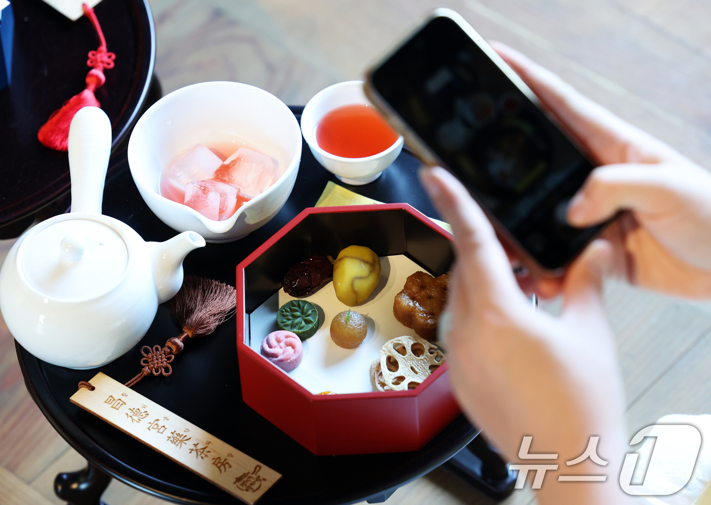 (서울=뉴스1) 오대일 기자 = 12일 오후 서울 종로구 창덕궁에서 열린 2025 창덕궁 약다방 행사에서 외국인 여성들이 궁중 다과를 체험하며 스마트폰 카메라로 사진을 찍고 있다. …