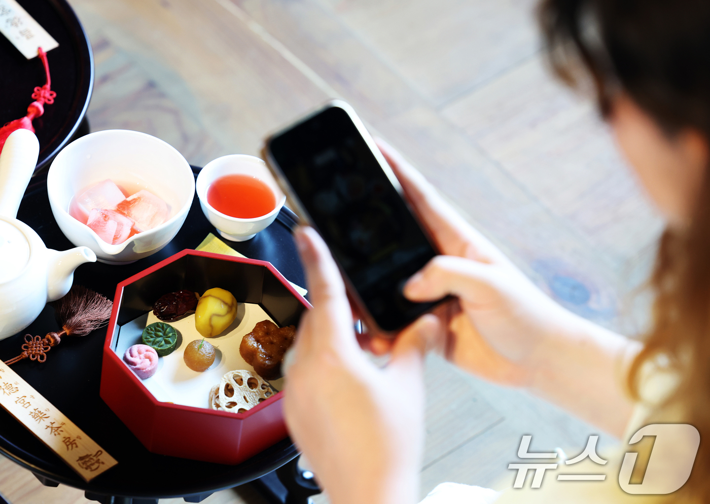 (서울=뉴스1) 오대일 기자 = 12일 오후 서울 종로구 창덕궁에서 열린 2025 창덕궁 약다방 행사에서 외국인 여성들이 궁중 다과를 체험하며 스마트폰 카메라로 사진을 찍고 있다. …
