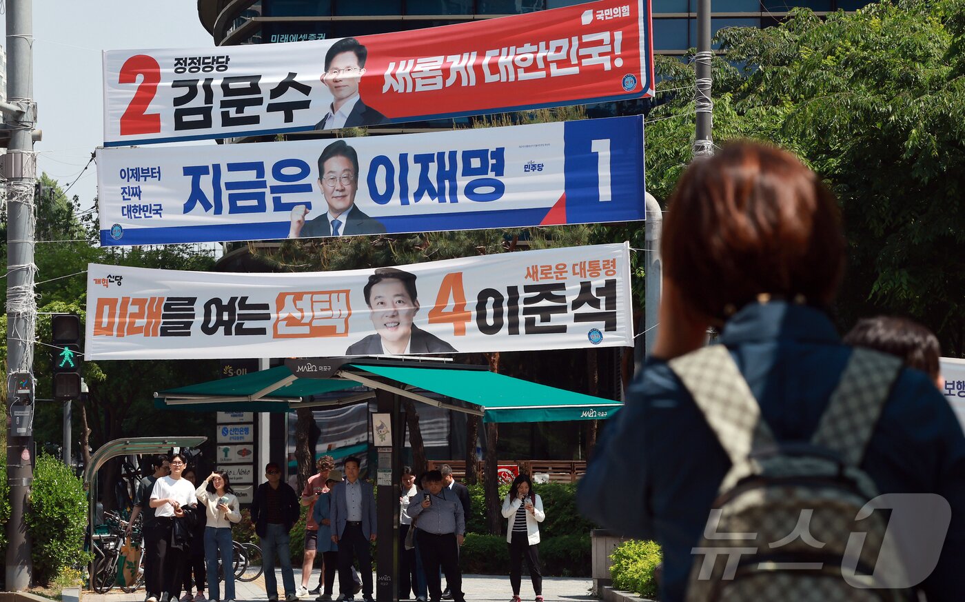 본문 이미지 - 제21대 대통령 선거 공식 선거운동이 시작된 12일 서울 시내 한 거리에 이재명 더불어민주당 대통령 후보와 김문수 국민의힘 대통령 후보, 이준석 개혁신당 대통령 후보의 현수막이 걸려 있다. 2025.5.12/뉴스1 ⓒ News1 김진환 기자