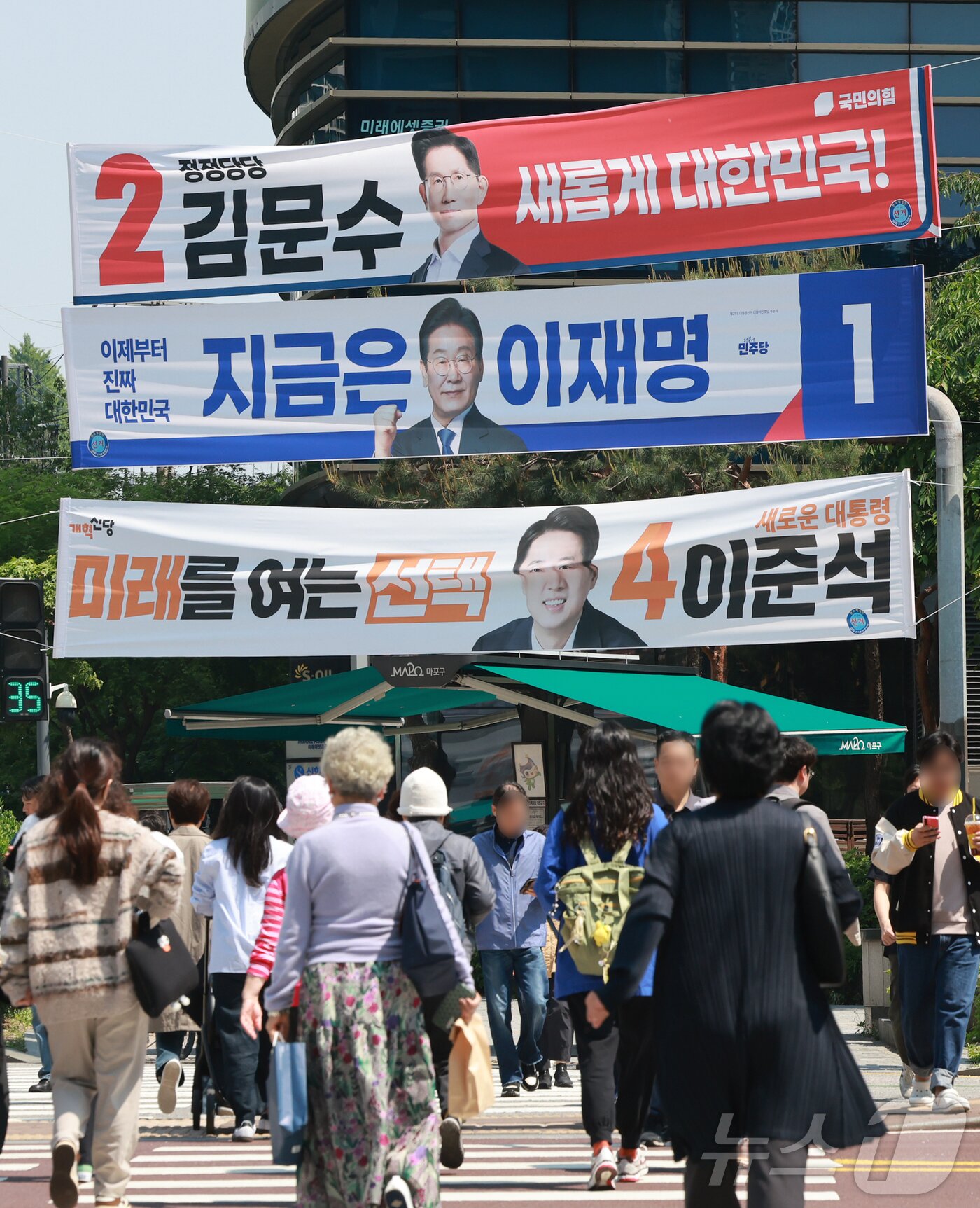 본문 이미지 - 제21대 대통령 선거 공식 선거운동이 시작된 12일 서울 시내 한 거리에 이재명 더불어민주당 대통령 후보와 김문수 국민의힘 대통령 후보, 이준석 개혁신당 대통령 후보의 현수막이 걸려 있다. 2025.5.12/뉴스1 ⓒ News1 김진환 기자