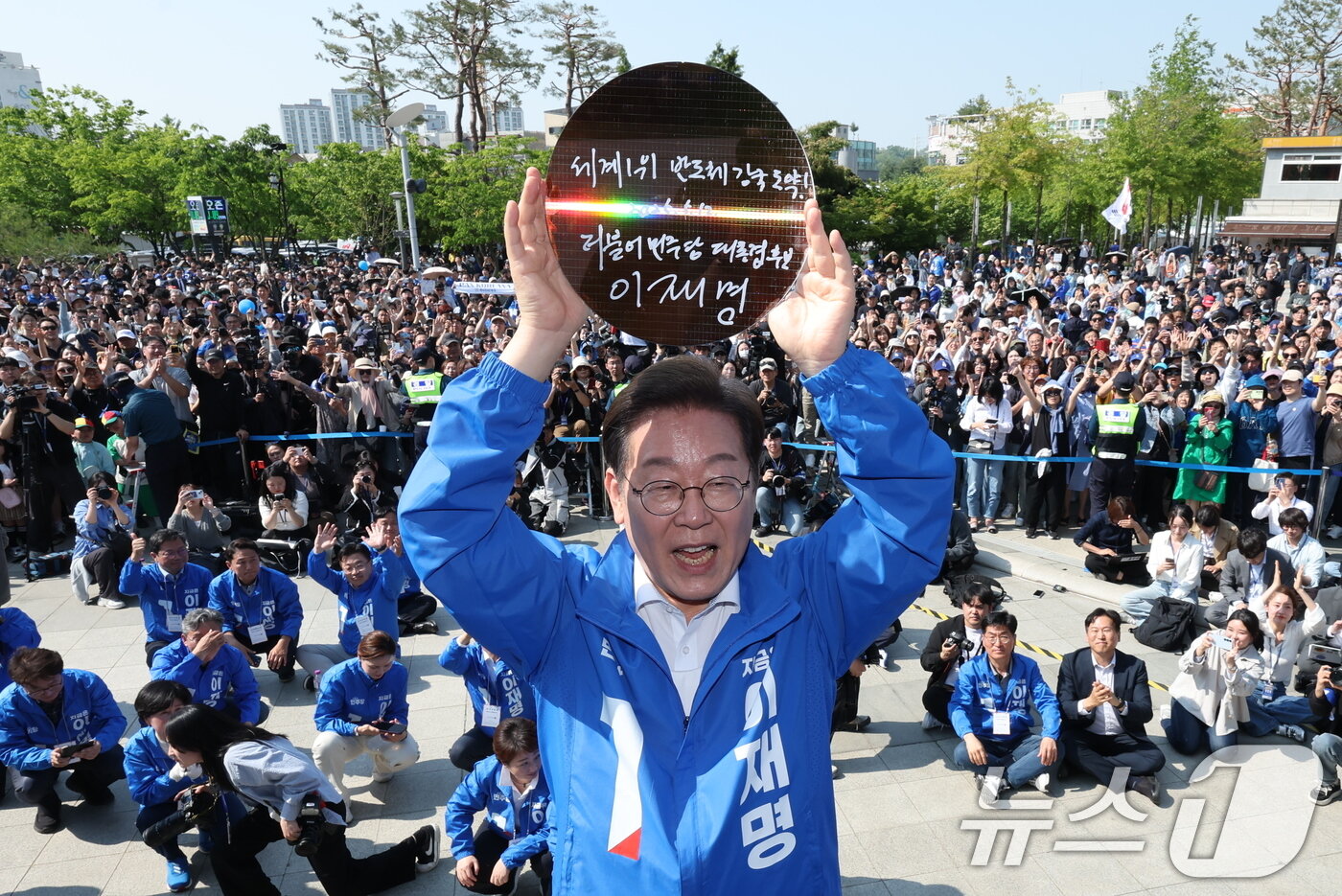 본문 이미지 - 이재명 더불어민주당 대통령 후보가 제21대 대통령 선거 공식 선거운동 첫날인 12일 오후 경기 화성시 동탄 센트럴파크 음악분수중앙광장에서 &#39;세계 1위 반도체 강국 도약!&#39;이라고 쓴 반도체 웨이퍼를 들어 보이고 있다. 2025.5.12/뉴스1 ⓒ News1 안은나 기자