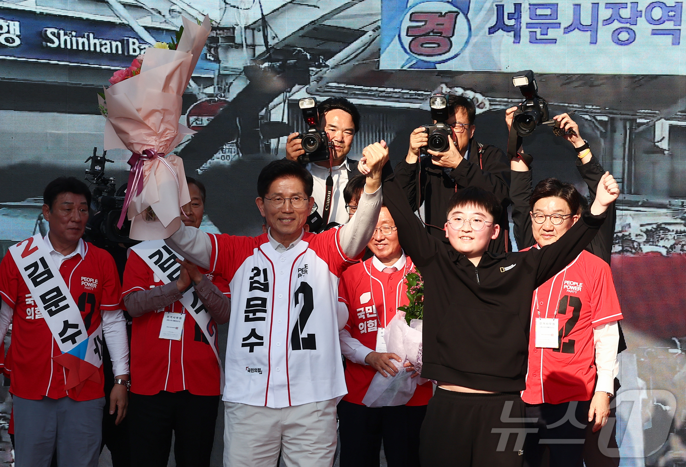 (대구=뉴스1) 김민지 기자 = 제21대 대통령 선거 공식 선거운동 첫날인 12일 김문수 국민의힘 대통령 후보가 대구 중구 서문시장에서 유세도중 학생과 손을 들어보이고 있다. 20 …