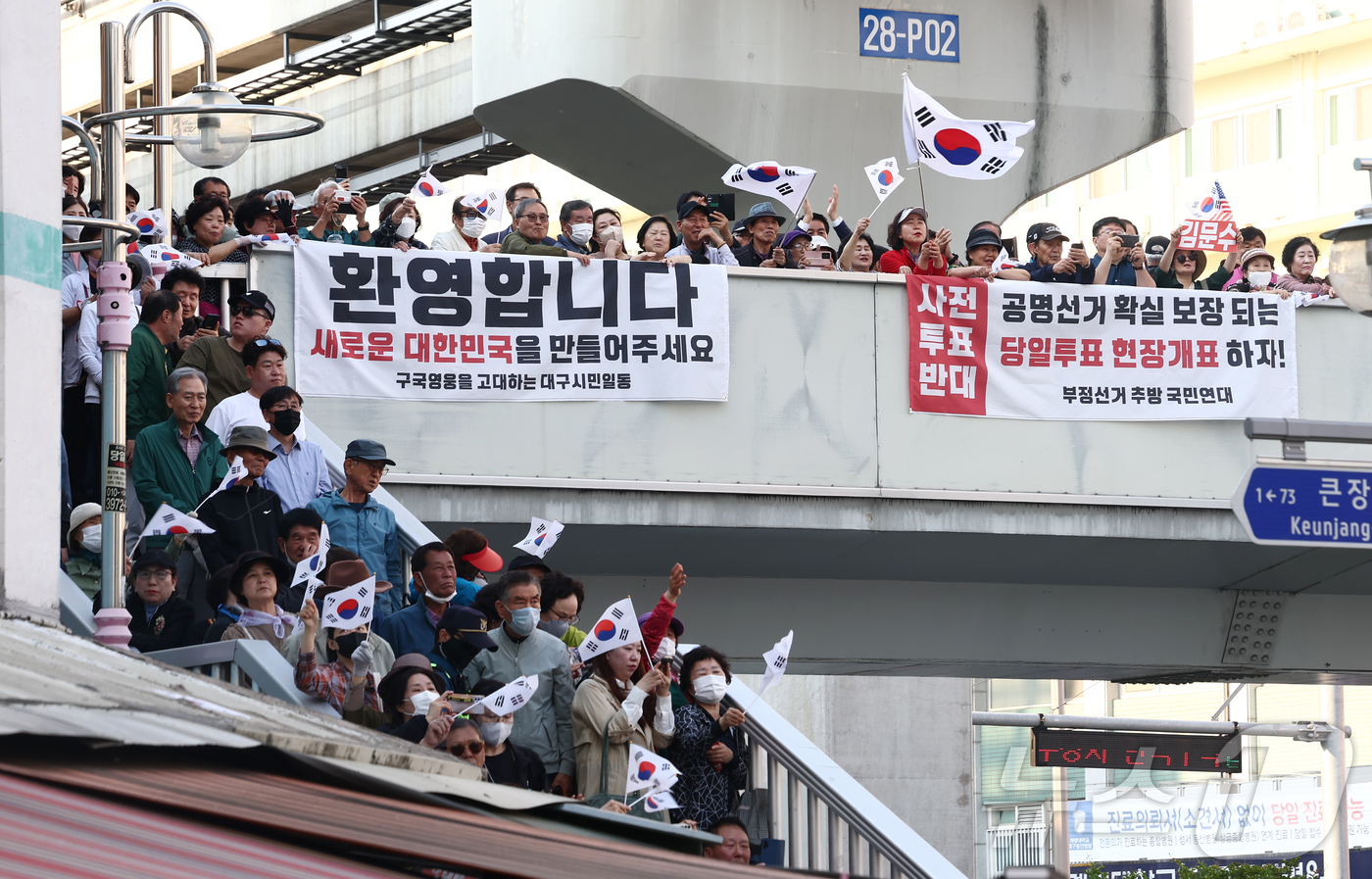 (대구=뉴스1) 김민지 기자 = 제21대 대통령 선거 공식 선거운동 첫날인 12일 김문수 국민의힘 대통령 후보가 대구 중구 서문시장에서 유세를 하고 있는 가운데 시민들이 태극기를 …