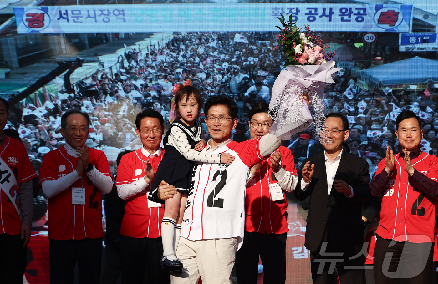 (대구=뉴스1) 김민지 기자 = 제21대 대통령 선거 공식 선거운동 첫날인 12일 김문수 국민의힘 대통령 후보가 대구 중구 서문시장에서 유세도중 어린이와 손을 들어보이고 있다. 2 …