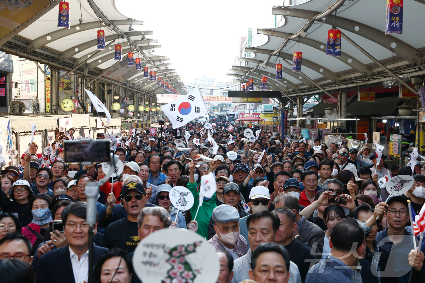 (대구=뉴스1) 김민지 기자 = 제21대 대통령 선거 공식 선거운동 첫날인 12일 김문수 국민의힘 대통령 후보가 대구 중구 서문시장에서 유세 중인 가운데 지지자들이 몰려 있다. 2 …