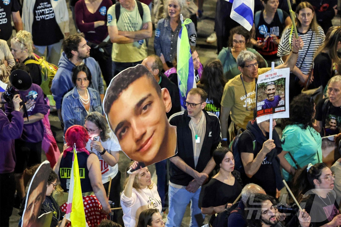 (텔아비브 AFP=뉴스1) 권영미 기자 = 팔레스타인 무장정파 하마스가 12일(현지시간) 석방을 약속한 미국계 이스라엘인 에단 알렉산더(가운데 사진). 그의 사진을 들고 한 여성이 …