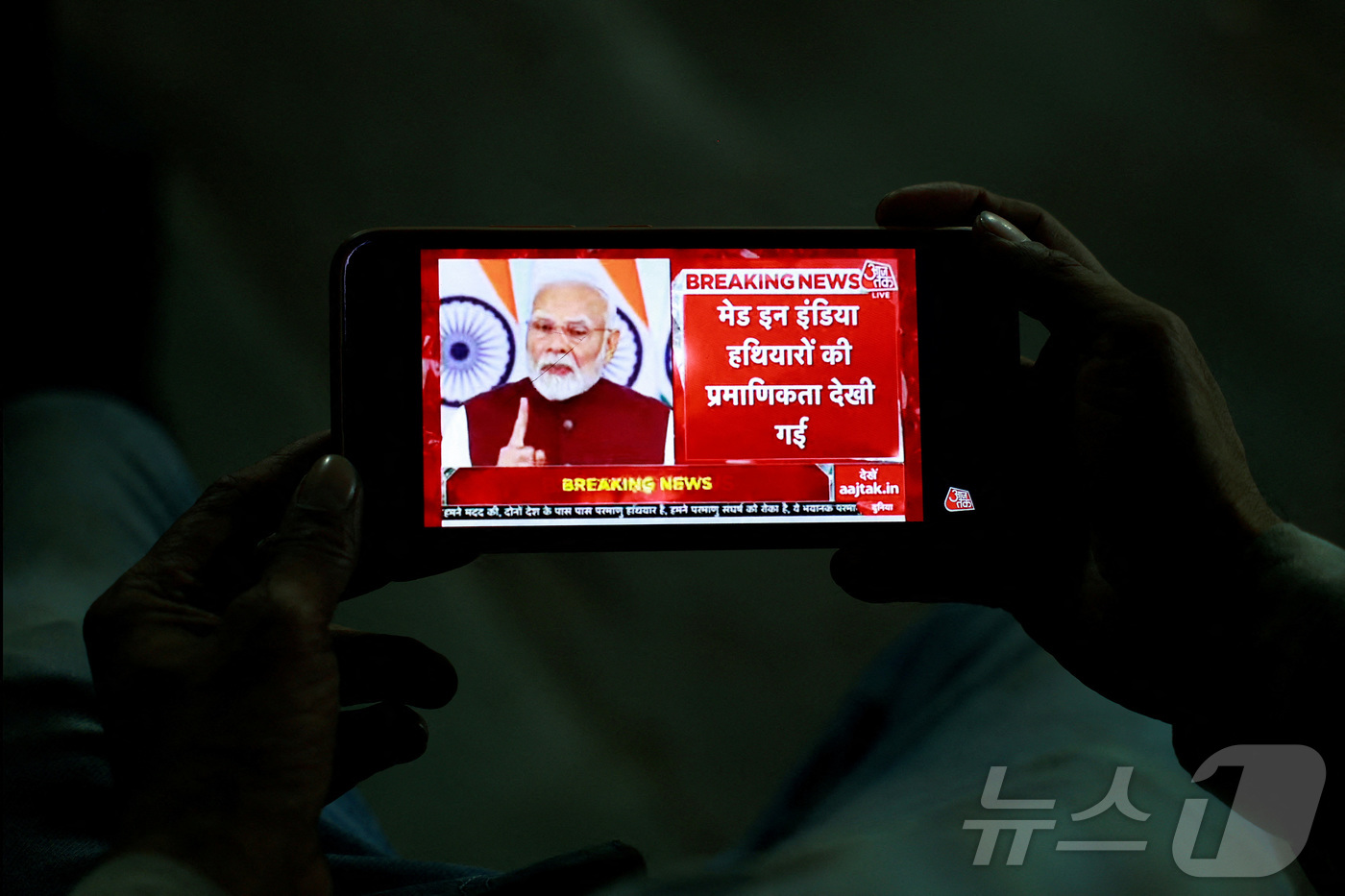 (델리 로이터=뉴스1) 정지윤 기자 = 인도 델리에서 한 남성이 휴대폰으로 나렌드라 모디 인도 총리의 대국민 연설을 시청하고 있다. 2025.05.12ⓒ 로이터=뉴스1