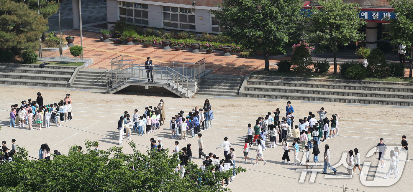 (대구=뉴스1) 공정식 기자 = 13일 오전 대구 수성구 매동초등학교에서 열린 봄철 화재대피훈련에서 교내 화재경보기가 울리자, 교실에서 수업하던 학생들이 운동장으로 대피하고 있다. …