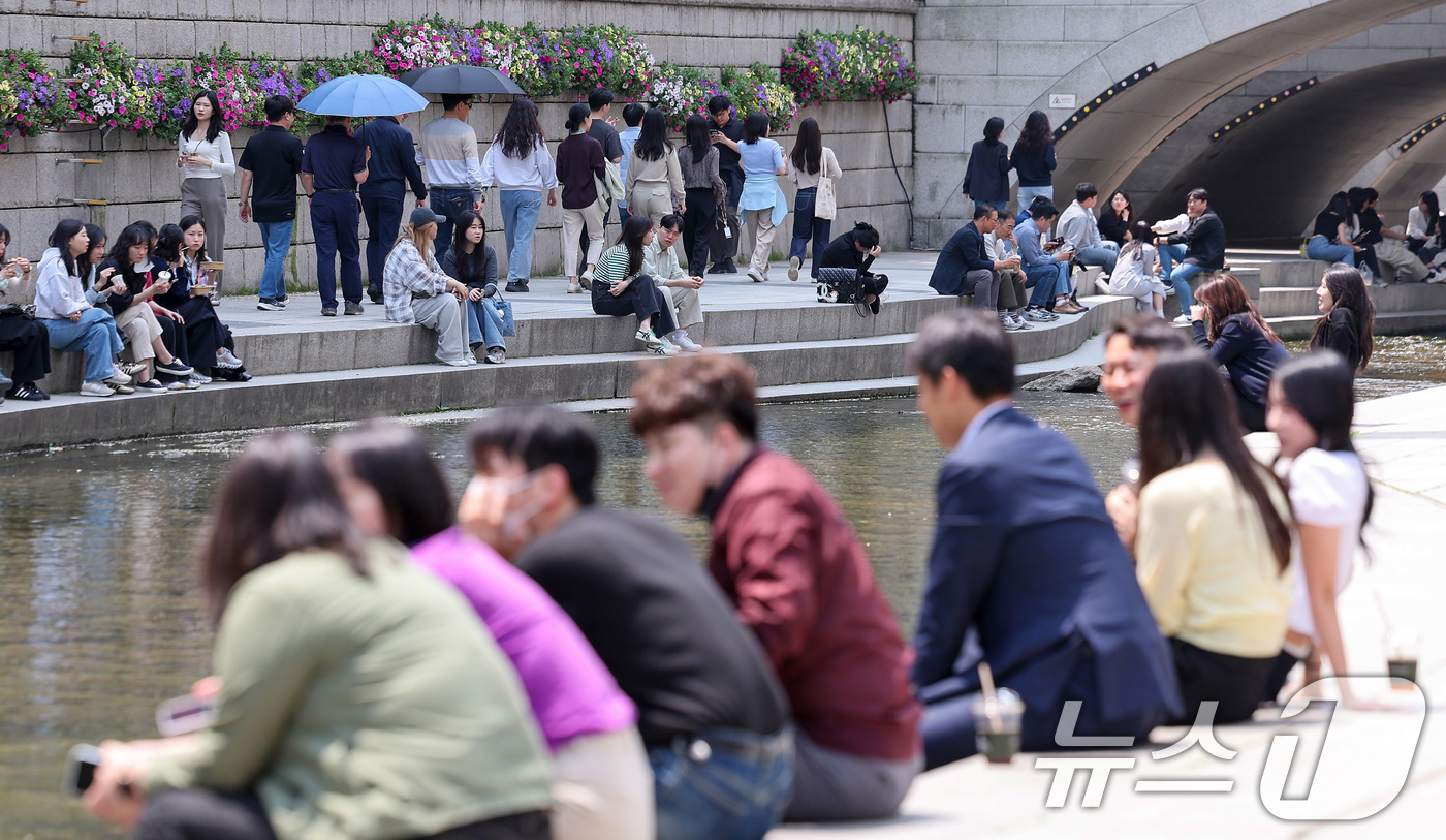(서울=뉴스1) 김성진 기자 = 서울 낮 최고 온도 25도를 기록하며 초여름 날씨를 보인 13일 서울 중구 청계천을 찾은 시민들이 휴식을 취하고 있다. 2025.5.13/뉴스1
