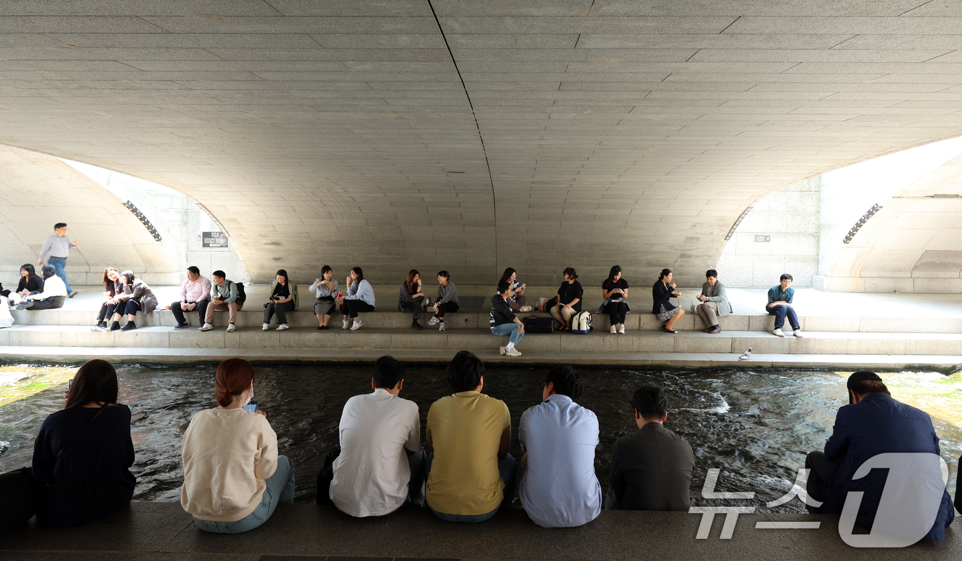 (서울=뉴스1) 김명섭 기자 = 서울 25도 등 초여름 날씨를 보인 13일 서울 청계천에서 직장인들이 점심시간을 이용해 그늘에서 휴식을 취하고 있다.  2025.5.13/뉴스1