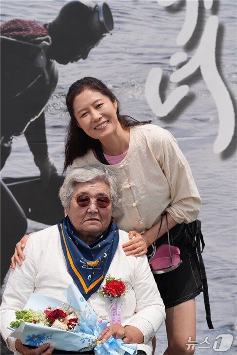 본문 이미지 - 배우 문소리가 지난 12일 김녕수산문화복합센터에서 열린 해녀 은퇴식에 참여해 은퇴 해녀와 기념촬영을 하고 있다. (제주해녀문화협회 제공. 재판매 및 DB 금지)