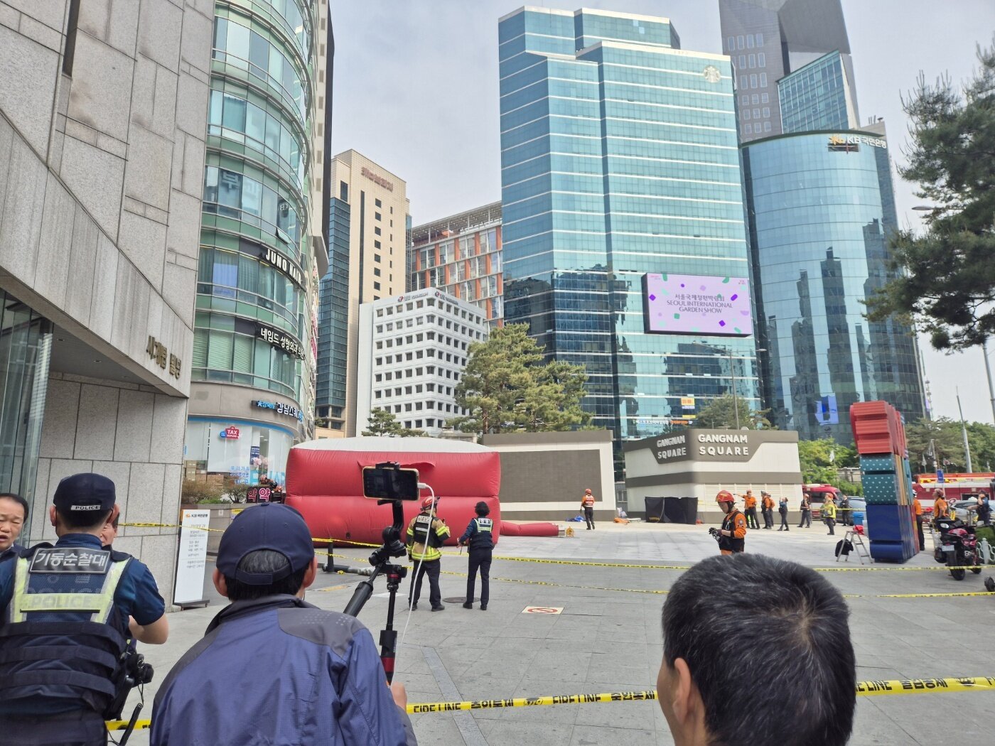본문 이미지 - 13일 서울 강남역 인근의 한 빌딩 옥상 난간에 한 시민이 올라 소방당국이 에어매트를 설치한 모습 . 2025.5.13/뉴스1 ⓒ News1 남해인 기자