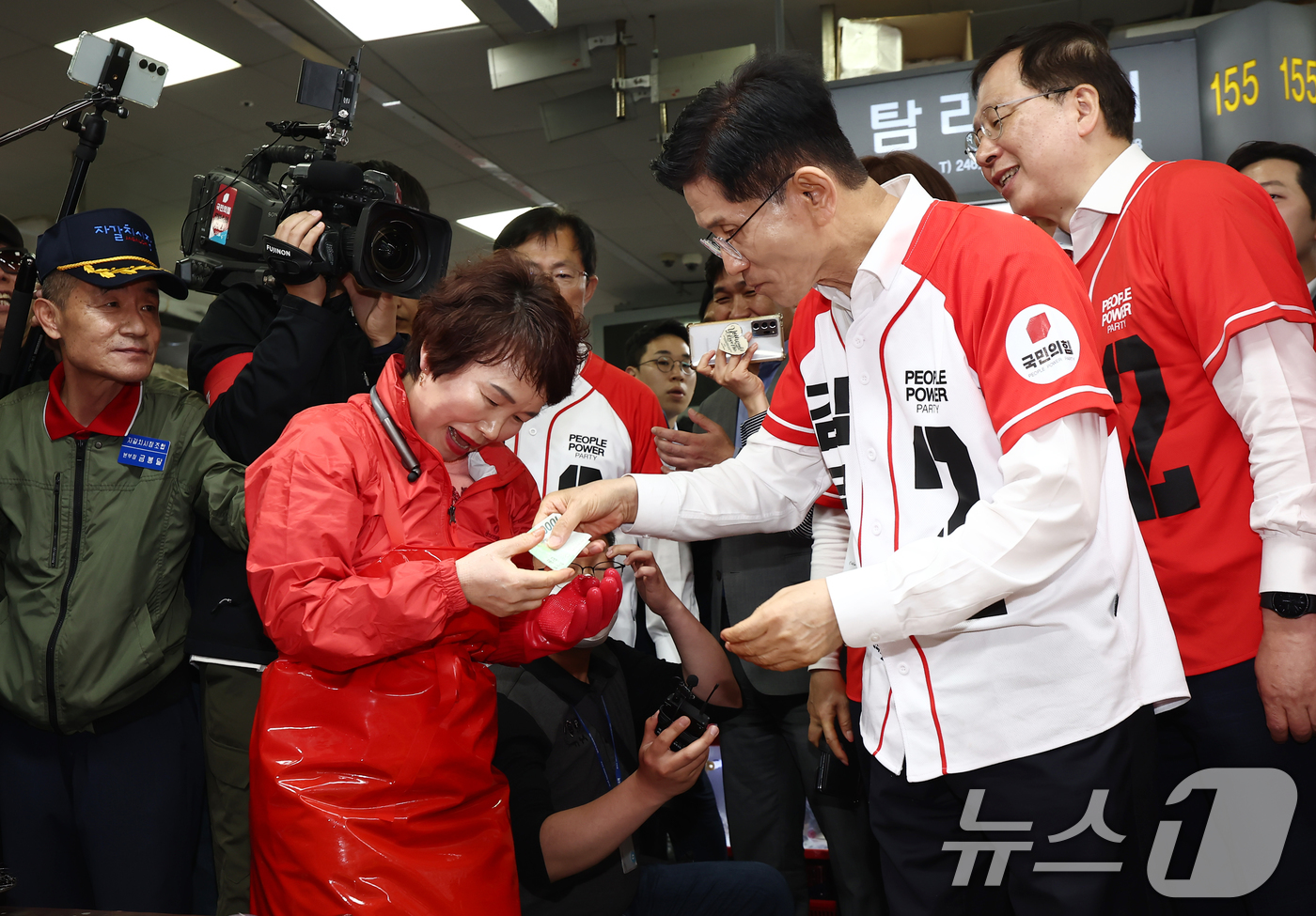 (부산=뉴스1) 김민지 기자 = 김문수 국민의힘 대통령 후보가 13일 부산 중구 자갈치시장에서 유세 중 독도새우를 맛본 뒤 상인에게 값을 지불하고 있다. 2025.5.13/뉴스1