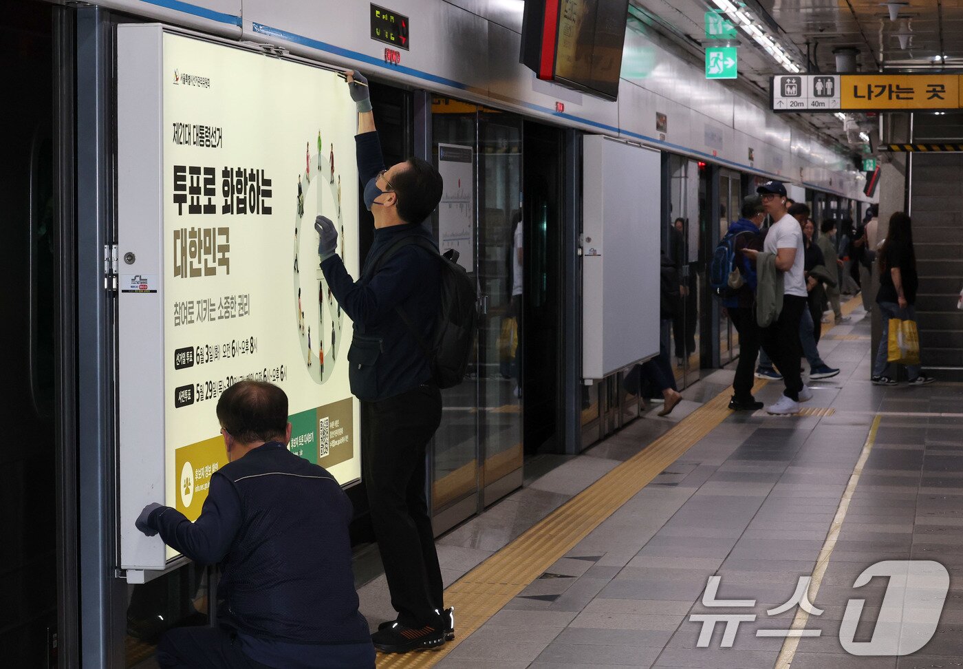 본문 이미지 - 제21대 대통령선거를 20일 앞둔 14일 오전 서울 종로구 지하철 혜화역 승강장 스크린도어에 선관위 관계자들이 대선 홍보물 래핑작업을 하고 있다. 2025.5.14/뉴스1 ⓒ News1 박세연 기자