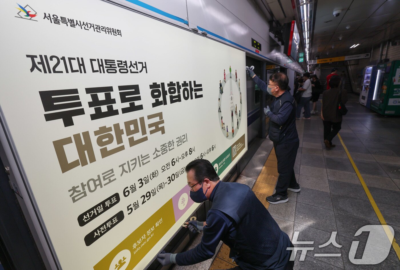 본문 이미지 - 제21대 대통령선거를 20일 앞둔 14일 오전 서울 종로구 지하철 혜화역 승강장 스크린도어에 선관위 관계자들이 대선 홍보물 래핑작업을 하고 있다. 2025.5.14/뉴스1 ⓒ News1 박세연 기자