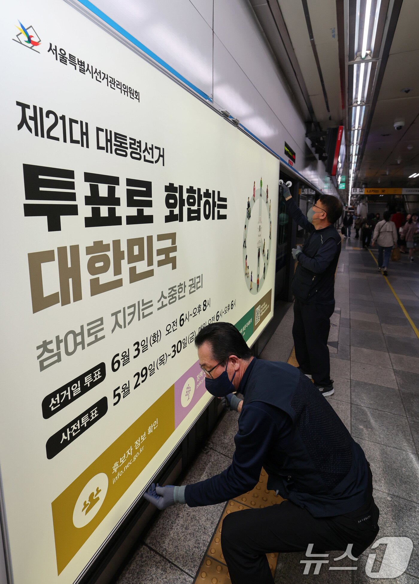 본문 이미지 - 제21대 대통령선거를 20일 앞둔 14일 오전 서울 종로구 지하철 혜화역 승강장 스크린도어에 선관위 관계자들이 대선 홍보물 래핑작업을 하고 있다. 2025.5.14/뉴스1 ⓒ News1 박세연 기자