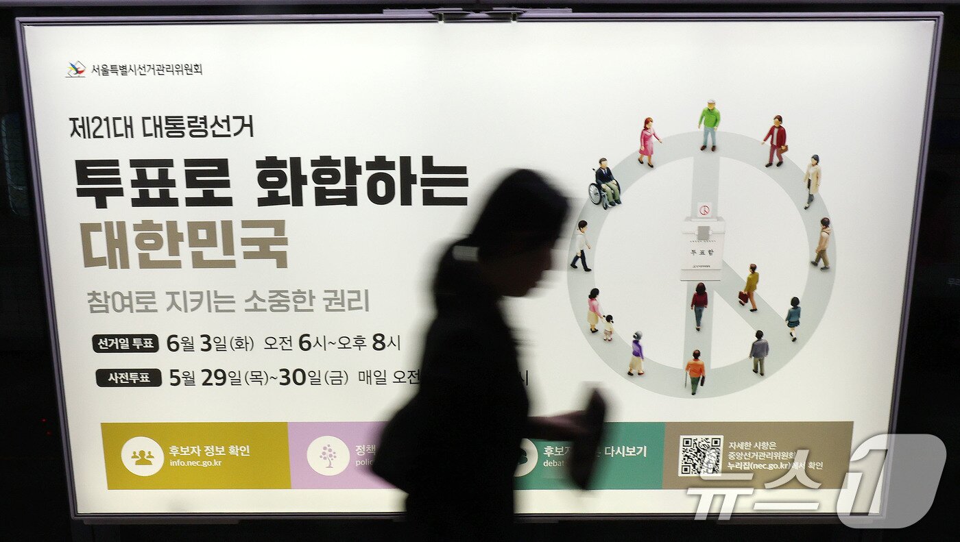 본문 이미지 - 제21대 대통령선거를 20일 앞둔 14일 오전 서울 종로구 지하철 혜화역 승강장 스크린도어에 래핑된 대선 홍보물 앞으로 한 시민이 지나고 있다. 2025.5.14/뉴스1 ⓒ News1 박세연 기자