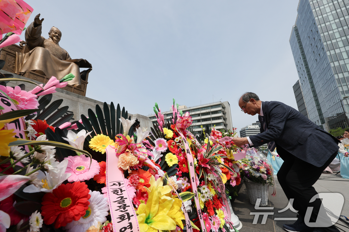 (서울=뉴스1) 허경 기자 = 14일 서울 종로구 광화문광장 세종대왕 동상 앞에서 열린 세종대왕 나신 날 시민참여 생일축하 행사에서 참석자들이 꽃을 놓고 있다. 2025.5.14/ …