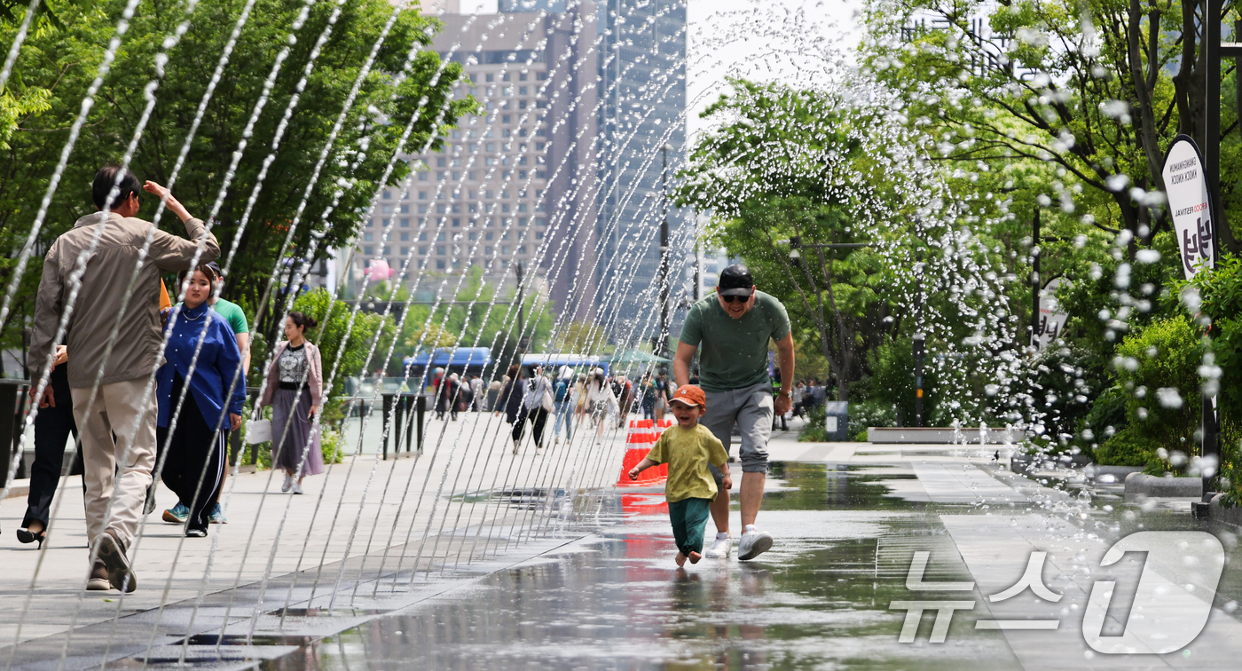 (서울=뉴스1) 허경 기자 = 서울 낮 최고 기온 26도 등 초여름 날씨을 보인 14일 서울 광화문광장 분수터널에서 외국인 관광객들이 더위를 식히고 있다. 2025.5.14/뉴스1 …