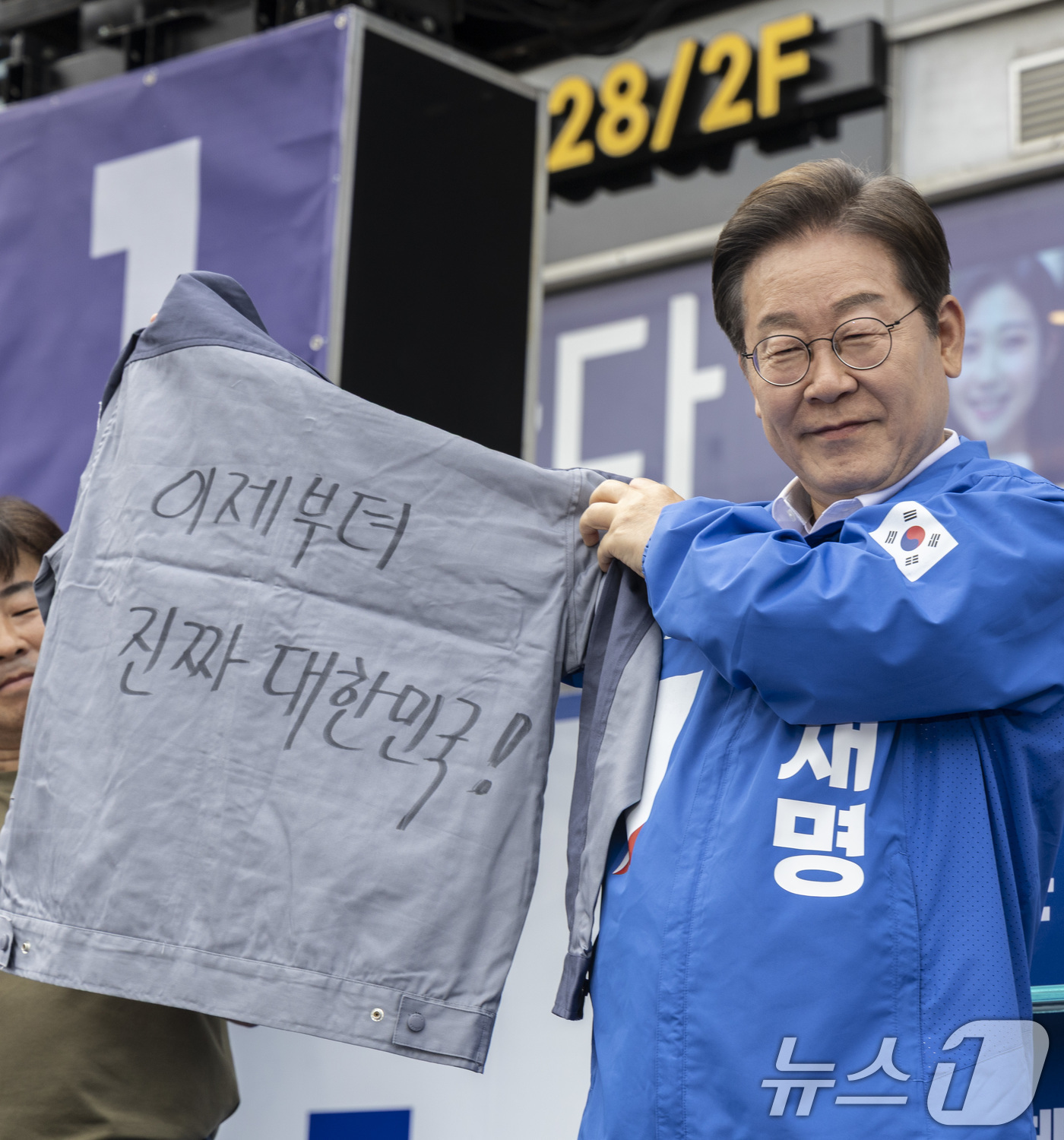 (창원=뉴스1) 안은나 기자 = 더불어민주당 이재명 대통령 후보가 14일 오후 경남 창원시 성산구 상남분수 광장에서 한 지지자가 건넨 '이제부터 진짜 대한민국!'이라는 선거 문구가 …