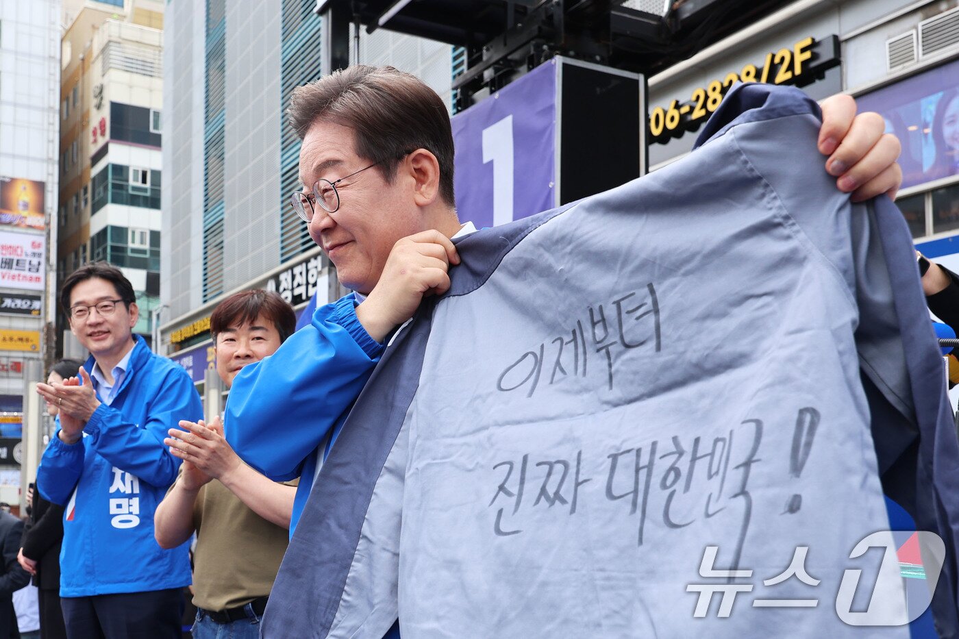 본문 이미지 - 이재명 더불어민주당 대통령 후보가 민주당 험지로 꼽히는 부산·경남&#40;PK&#41; 지역 유세에 나선 14일 경남 창원시 상남분수광장에서 열린 집중유세에서 송순호 경남도당위원장으로부터 &#39;이제부터 진짜 대한민국!&#39; 문구가 써진 작업복을 전달 받고 있다. &#40;공동취재&#41; 2025.5.14/뉴스1 ⓒ News1 안은나 기자