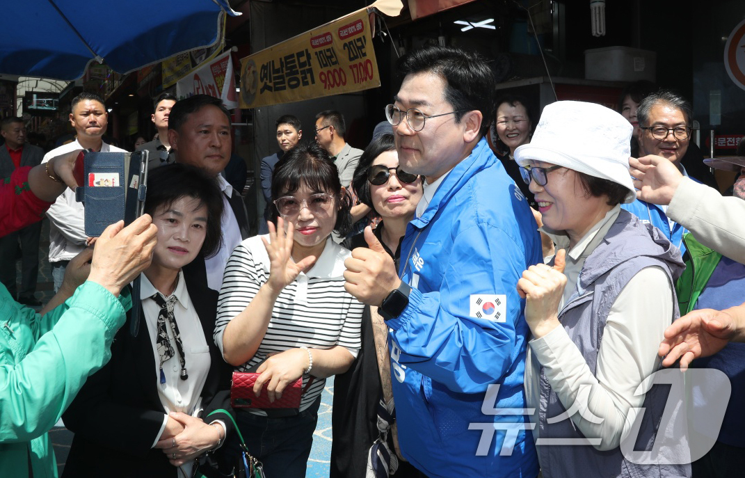 (제천=뉴스1) 손도언 기자 = 박찬대 더불어민주당 총괄선거대책위원장이 14일 충북 제천 중앙시장을 찾아 시민들과 인사하며 이재명 후보의 지지를 호소하고 있다. 2025.5.14/ …