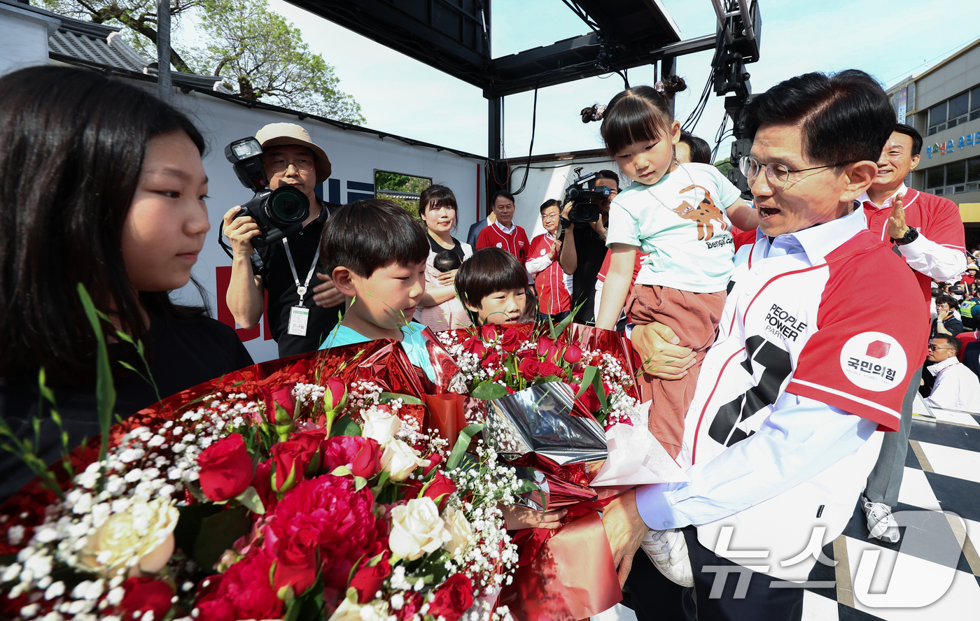 (밀양=뉴스1) 김민지 기자 = 김문수 국민의힘 대통령 후보가 14일 경남 밀양시 밀양관아 앞에서 열린 유세에서 정용우, 손정혜 씨의 육남매 자녀들에게 꽃을 전달 받고 있다. 20 …