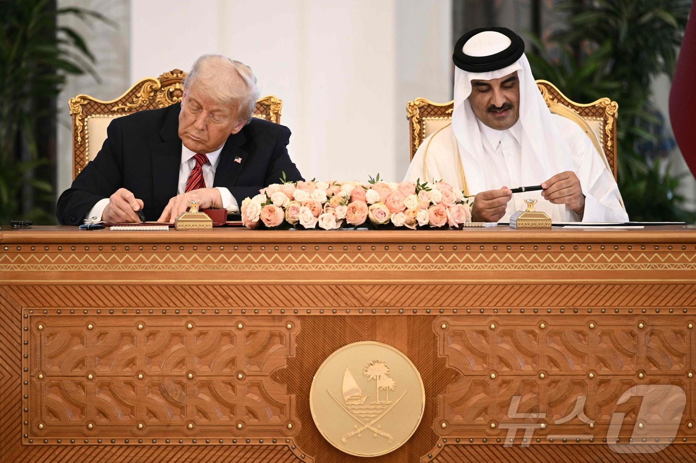 (도하 AFP=뉴스1) 우동명 기자 = 도널드 트럼프 미국 대통령이 14일(현지시간) 중동 순방 중 도하 왕궁에서 셰이크 타밈 빈 하마드 알사니 카타르 국왕과 협약서에 서명을 하고 …