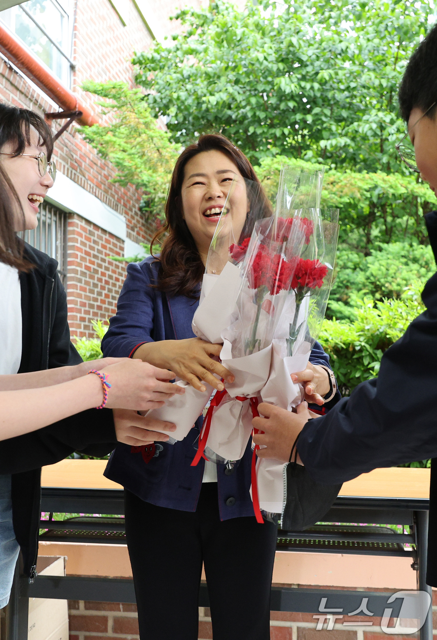 (서울=뉴스1) 신웅수 기자 = 스승의 날인 15일 오전 서울 노원구 동일초등학교에서 선생님이 학생들에게 꽃을 선물받고 있다. 2025.5.15/뉴스1