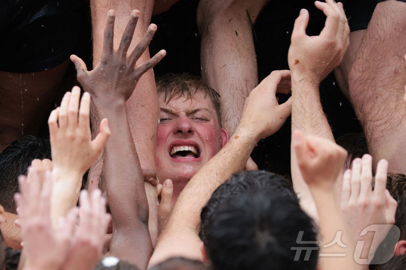 본문 이미지 - 미국 해군사관학교에서 사관생도들이 14일(현지시간) 미국 메릴랜드 주 아나폴리스 미 해군 사관학교에서 '딕시 컵'을 떨어뜨리기 위해 인간 피라미드를 만들어 헌던 기념물 꼭대기에 오르고 있다.  ⓒ AFP=뉴스1