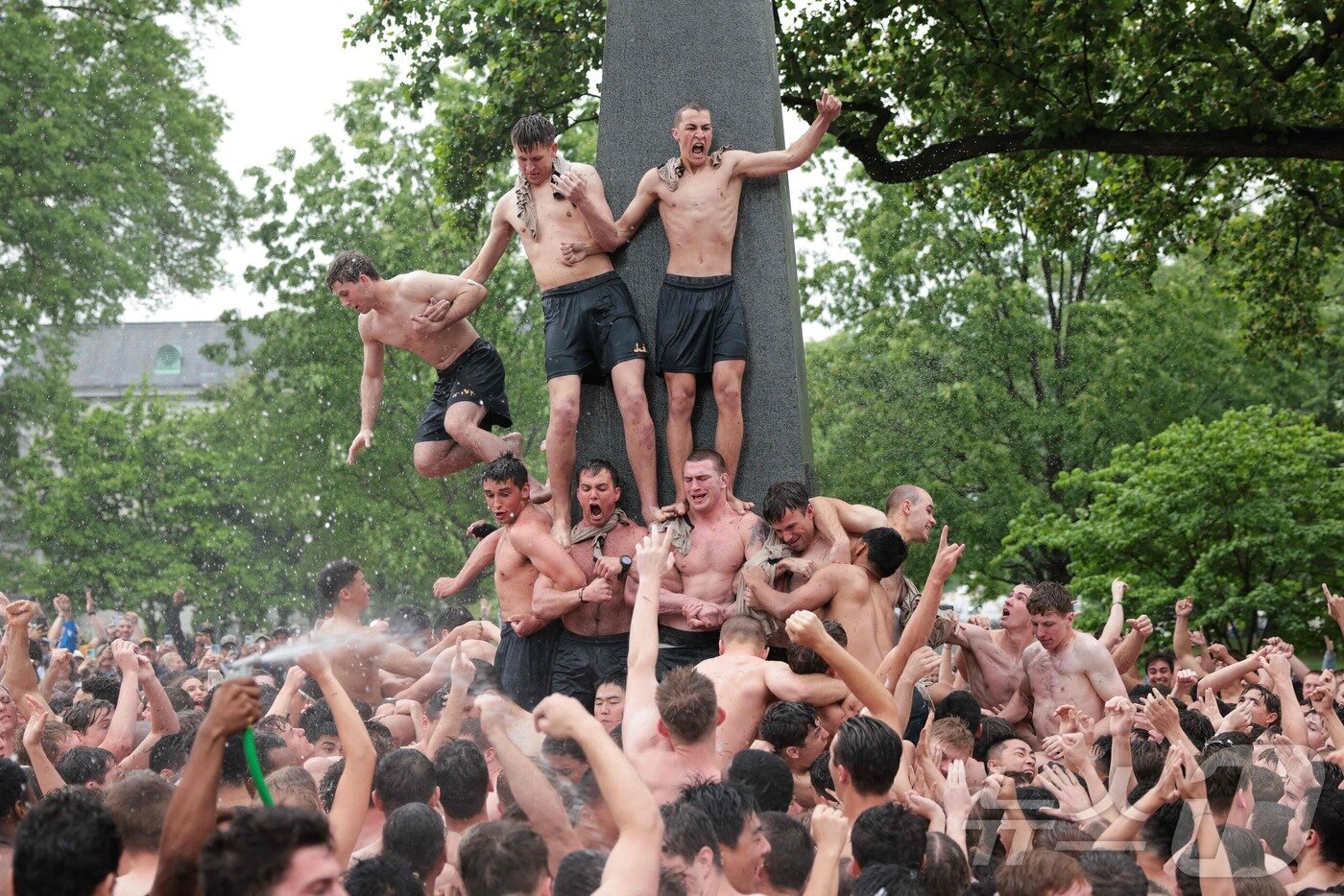 본문 이미지 - 미국 해군사관학교에서 사관생도들이 14일(현지시간) 미국 메릴랜드 주 아나폴리스 미 해군 사관학교에서 '딕시 컵'을 떨어뜨리기 위해 인간 피라미드를 만들어 헌던 기념물 꼭대기에 오르고 있다.  ⓒ AFP=뉴스1