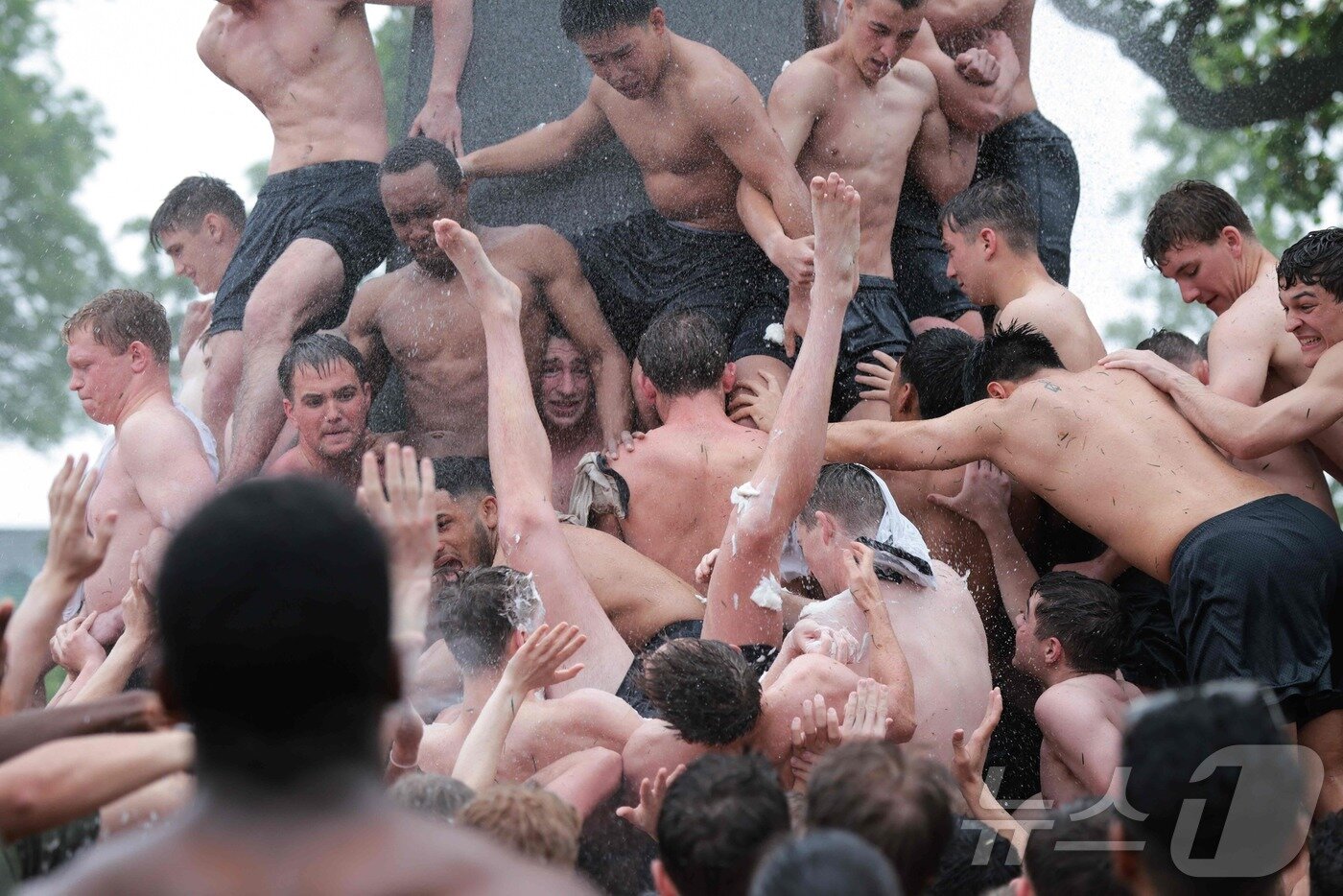 본문 이미지 - 미국 해군사관학교에서 사관생도들이 14일(현지시간) 미국 메릴랜드 주 아나폴리스 미 해군 사관학교에서 '딕시 컵'을 떨어뜨리기 위해 인간 피라미드를 만들어 헌던 기념물 꼭대기에 오르고 있다.  ⓒ AFP=뉴스1